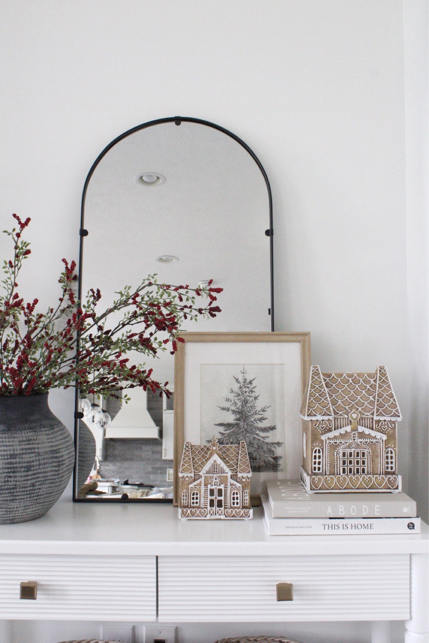Christmas console decor. 

Arched mirror, gingerbread houses from At Home, red berry stems from target. Vase is pottery barn 

#LTKhome #LTKHoliday #LTKSeasonal