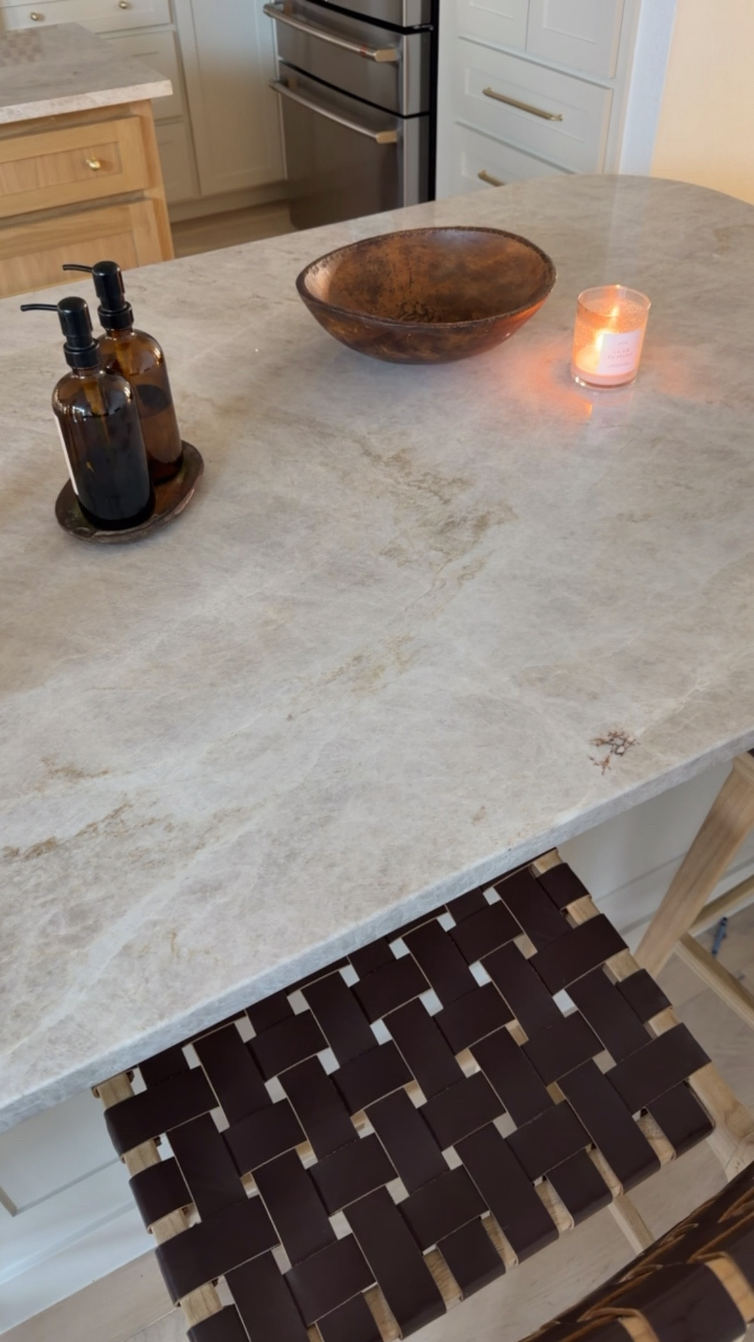 Love keeping our island decor minimal + simple here! Counter is Taj Mahal quartzite 🤎

Kitchen decor, soap bottles, leather counter stools, woven stools 

#LTKHome
