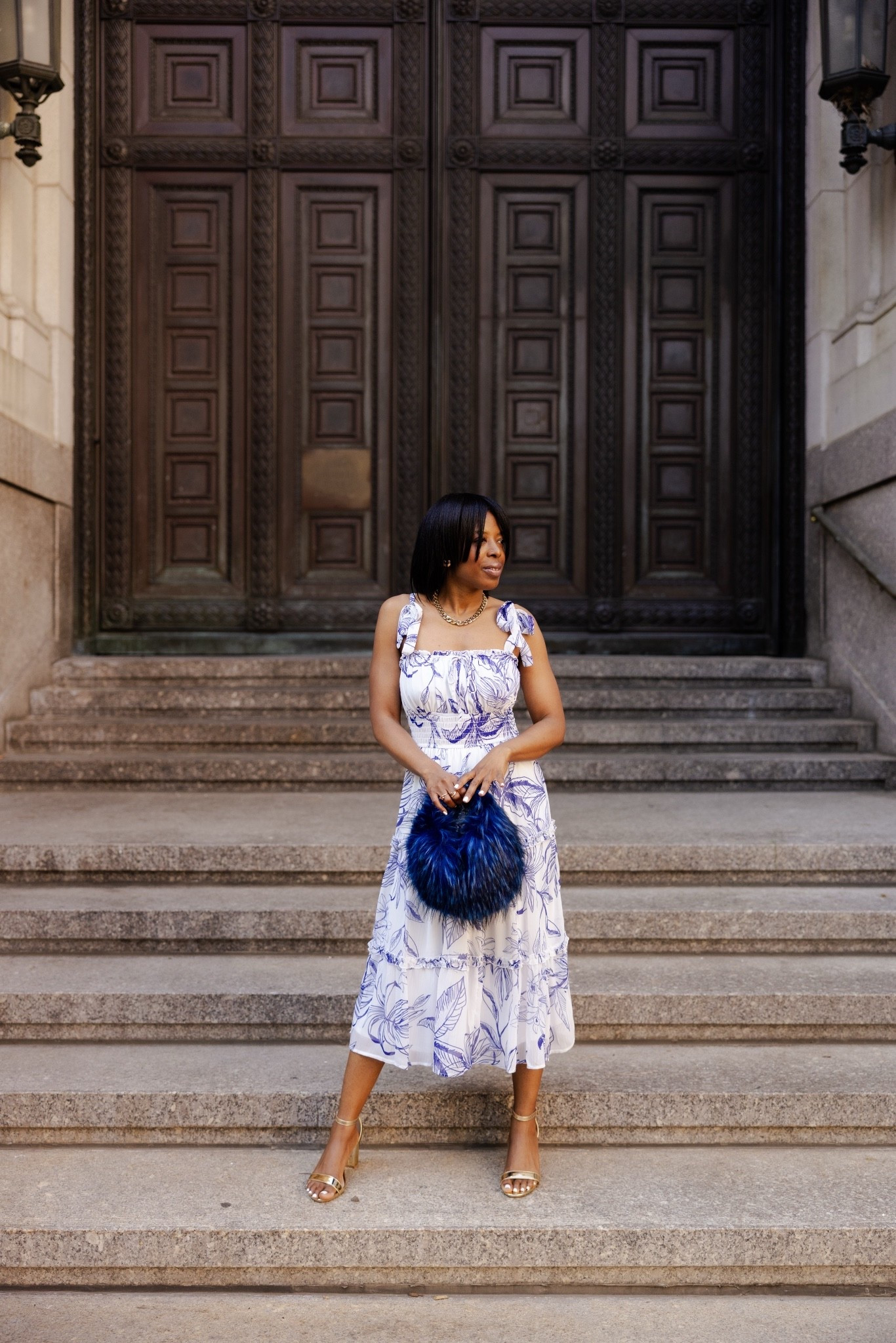 This look instantly gave me fashion travel editorial vibes. The flowy blue and white dress paired with the gold heels and furry blue bag made the whole outfit feel effortless but still elevated. One of my favorite street style looks from this shoot for sure. Linking the outfit details here.

#LTKTravel #LTKSeasonal #LTKootd