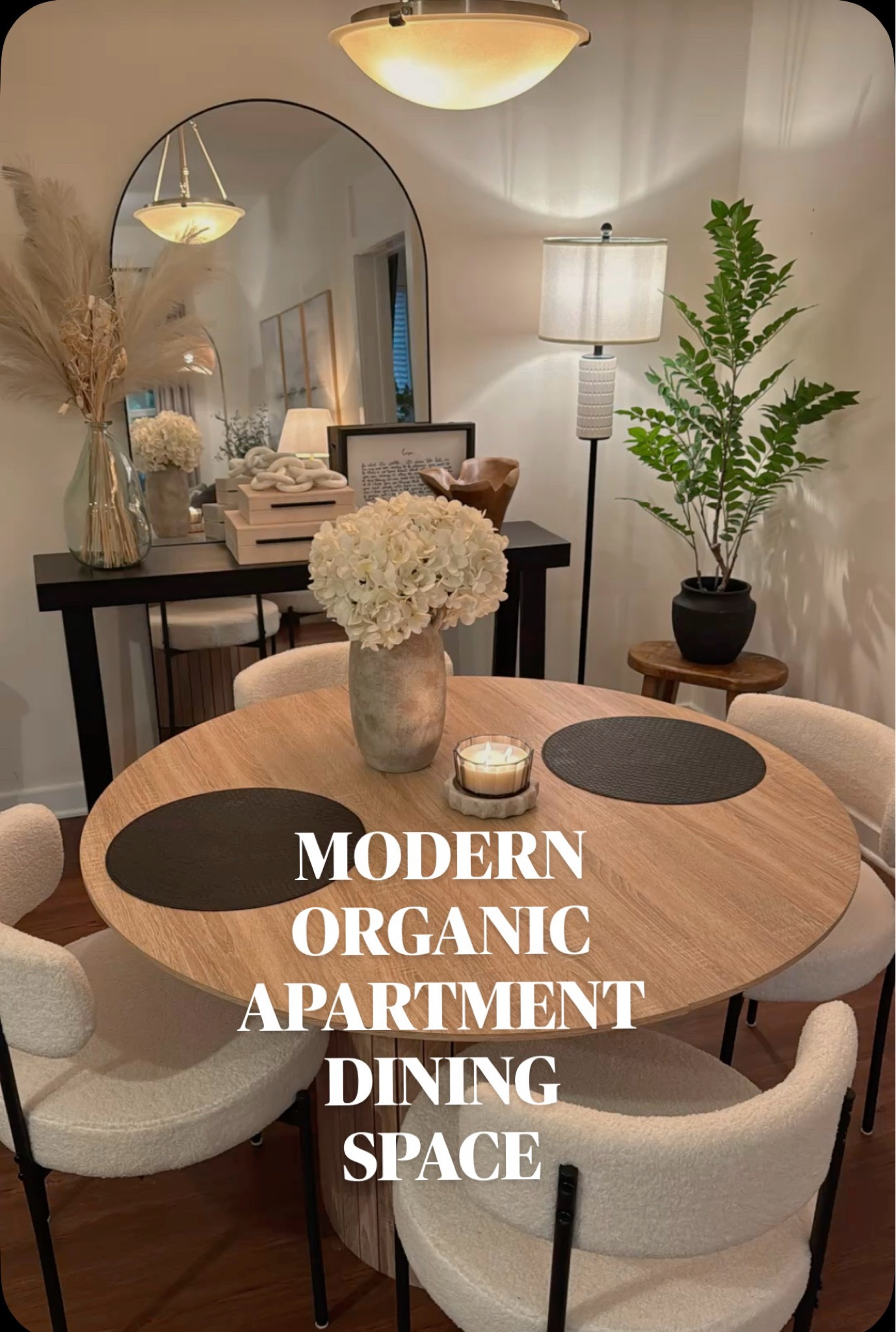 My dream dining space lately 🤍 Warm wood tones, boucle dining chairs, soft ambient lighting, neutral decor, cozy candles, and earthy textures all come together for the perfect modern organic apartment vibe. Sharing affordable home decor inspiration, apartment styling ideas, and elevated cozy decor that makes your home feel calm, welcoming, and designer-inspired. #modernorganic #diningroomdecor #apartmentdecor #neutralhome #cozyhome #homedecor #ambientlighting #earthyhome #amazonhome #interiordesign