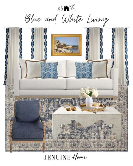 Blue and white living room. Gold framed landscape art. Blue and white throw pillow. Neutral tasselled throw pillow. White traditional couch. Blue and white traditional rug. Gold decor dish. Daffodil faux flowers. Wooden bead decor. Brass whale statue. Coastal living room. Coastal decor. Blue spindle chair. Blue and white embroidery edged curtains. Scalloped edged coffee table  