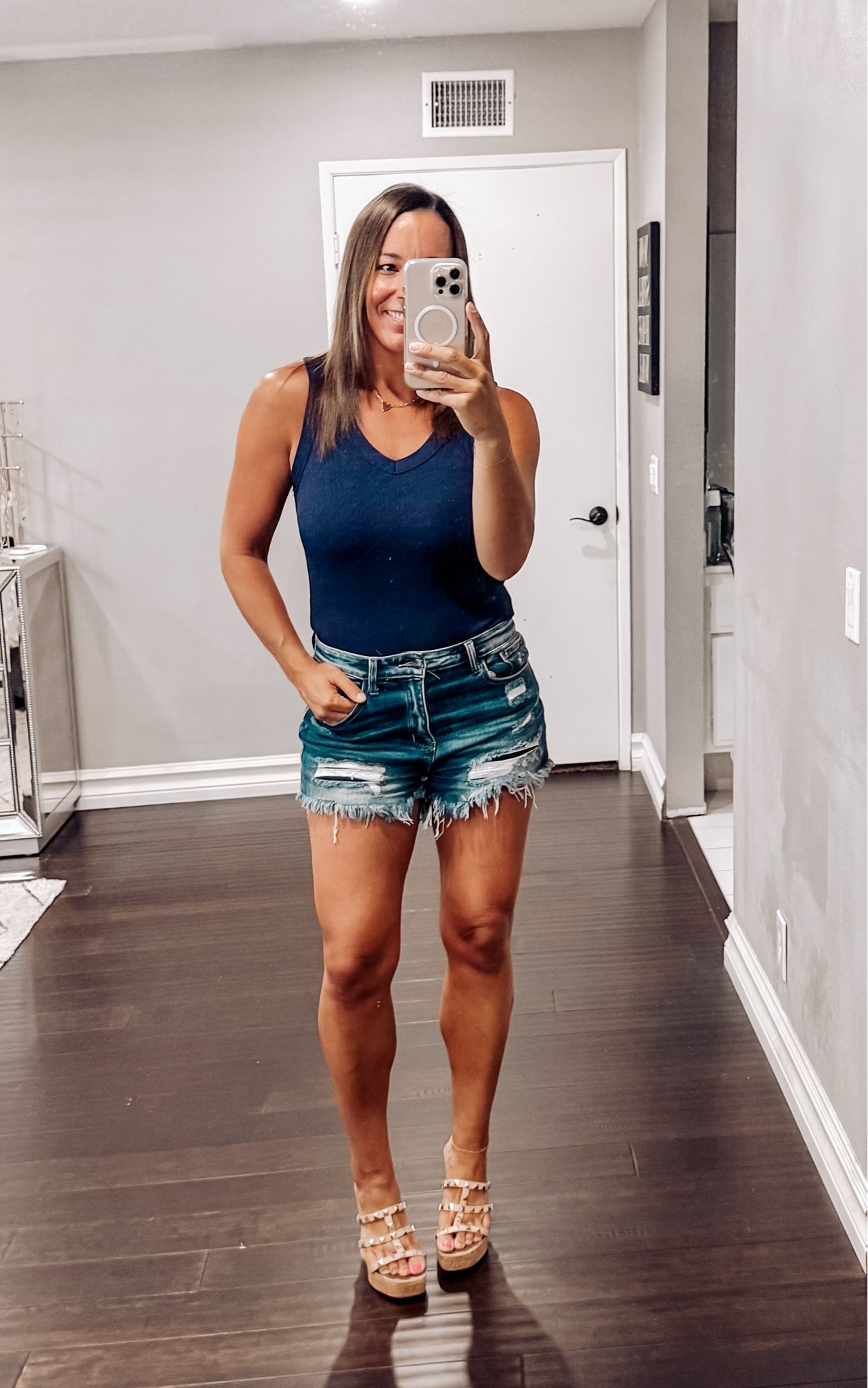 OOTD! This navy tank is one of those pieces you’ll reach for all season long! The fit is flattering, comfortable, and easy to dress up or down. Paired with distressed denim shorts and wedges, it’s the perfect look for summer date nights, brunch, vacations, or everyday mom life. 💙☀️

Shop this effortless summer outfit and more of my favorites on LTK! Follow me for affordable fashion finds, everyday style, and outfit inspiration. #AffordableFashion #MomStyle #SummerOutfit #ClosetStaples 
#DateNight #CasualChic