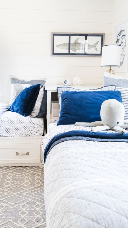 Coastal style shared boys bedroom with pottery barn storage beds, blue and white bedding, nautical themed, blankets, area rug, and more kids bedroom home decor

#LTKfamily #LTKkids #LTKhome