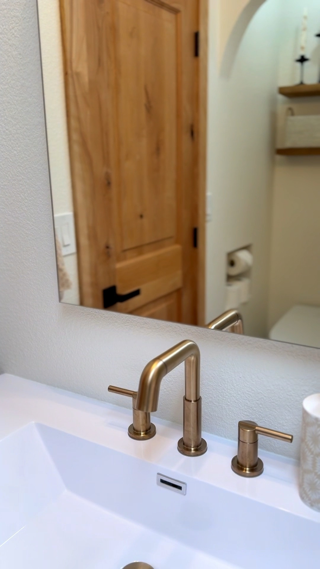 Clever design, hidden in plain sight: the arched mirror doubles as a medicine cabinet, while the faucet features a detachable sprayer. 

 #LTKHome