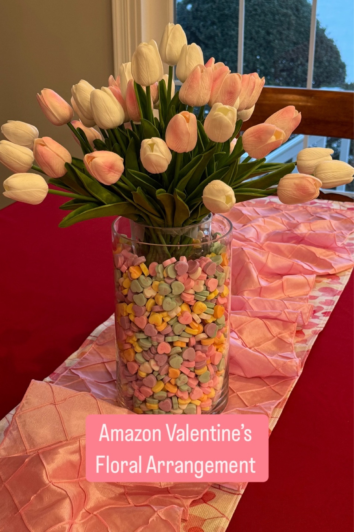💘 Want a cute and easy Valentine’s Day DIY? 💘

I put together this floral arrangement in minutes using simple, affordable items from Amazon! 🎉 

It is perfect for a last-minute decor upgrade or as a sweet gift.

Here’s what you’ll need:
•    Stackable vases
•    @brachscandy Conversation Hearts (yes, I may have snacked on a few 😜)
•    Faux silk tulips (I used 40—20 pink, 20 white!)
•    Scotch tape to add some height and keep everything in place!

It is a festive way to brighten up your kitchen counter or add some love to your table. 💕 

I am OBSESSED with how it turned out!

#LTKHome