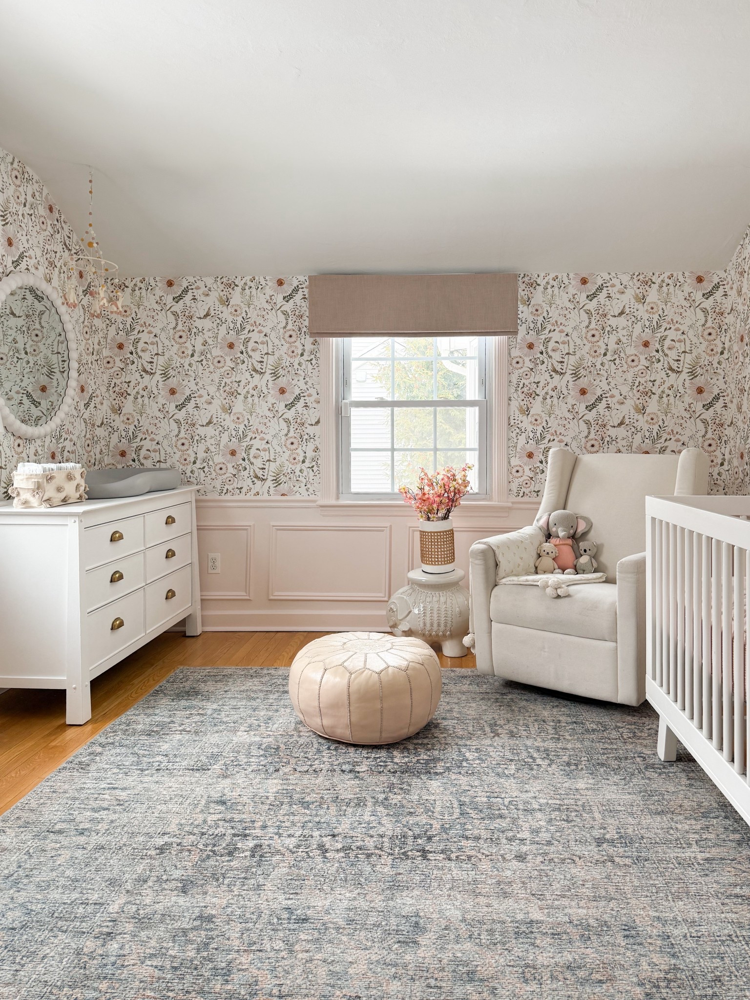 This nursery feels so calm and elevated with the perfect mix of soft florals, warm neutrals, and cozy textures. I love how the wallpaper adds subtle pattern while the layered pieces like the upholstered glider, pouf, and vintage inspired rug keep the space feeling timeless and collected. Such a beautiful balance of function and design for an everyday lived in space.

neutral nursery design, floral wallpaper nursery, cozy nursery inspiration, nursery glider chair, vintage style area rug, soft neutral home decor, blush nursery accents, timeless nursery decor, layered nursery design, classic nursery furniture, serene kids room aesthetic girlonthehudson

#LTKHome #LTKKids #LTKBaby