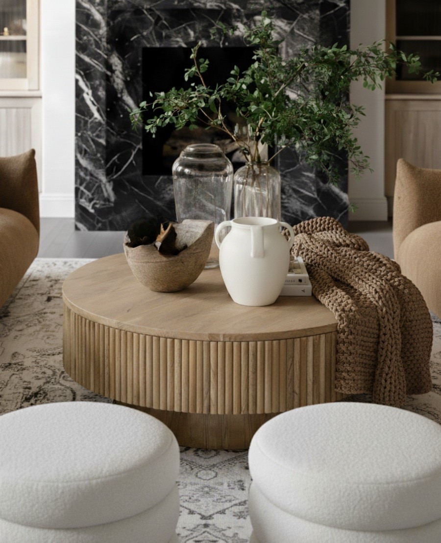 Fall comfort, elevated.  A chunky knit throw drapes effortlessly across a round wood coffee table, surrounded by soft white boucle ottomans and a camel sofa that radiates warmth. Layered ceramic vases and natural greenery add an organic touch, while the black marble fireplace grounds the space with dramatic contrast. Every texture and tone was chosen to make this living room feel cozy, curated, and undeniably fall-ready.

 Shop the look:
Chunky knit throw | Round ribbed coffee table | White boucle ottomans | Camel sofa | Ceramic vases | Textured rug | Black marble fireplace | Fall home decor 

#LTKSaleAlert #LTKHome