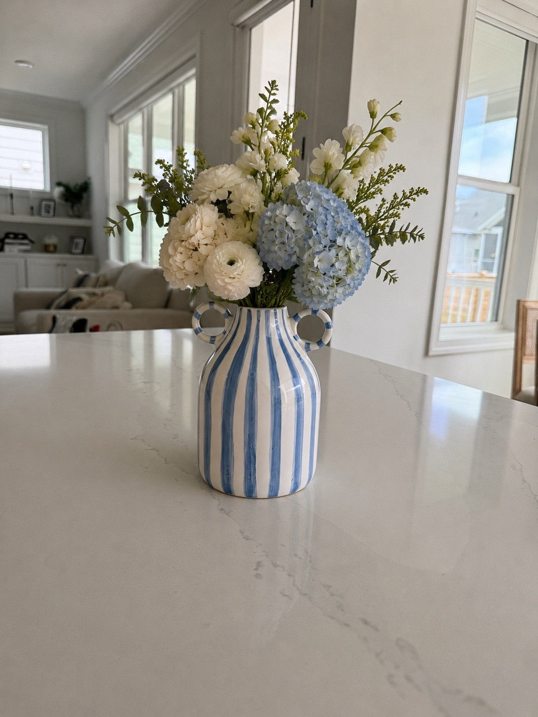 A little blue-and-white moment that’s making me smile every time I walk into the kitchen. This striped vase paired with fresh blooms adds the perfect touch of coastal charm and summer color to our home. One of those simple decor pieces that makes a space feel instantly brighter and more inviting. 🌿🤍💙

#LTKSeasonal #LTKHome #LTKmomlife