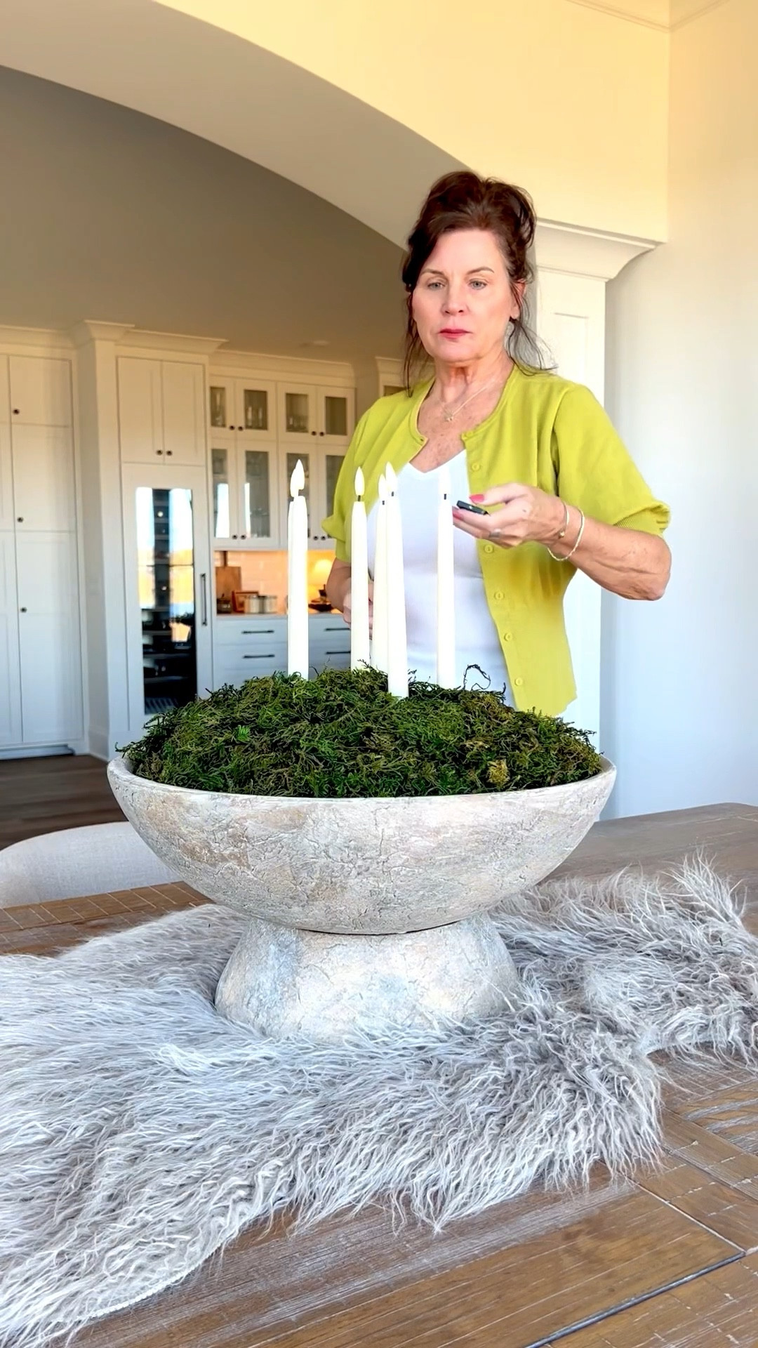 This simple table centerpiece is a mix of elegance with candles and rustic with a fur throw and concrete bowl. It works great for winter and the holidays. I used Gorilla tape to hold the candles in place. Remember to turn the button on before placing them, then use the remote. They’re my favorite LED taper candles  

#LTKHome #LTKSeasonal #LTKHoliday