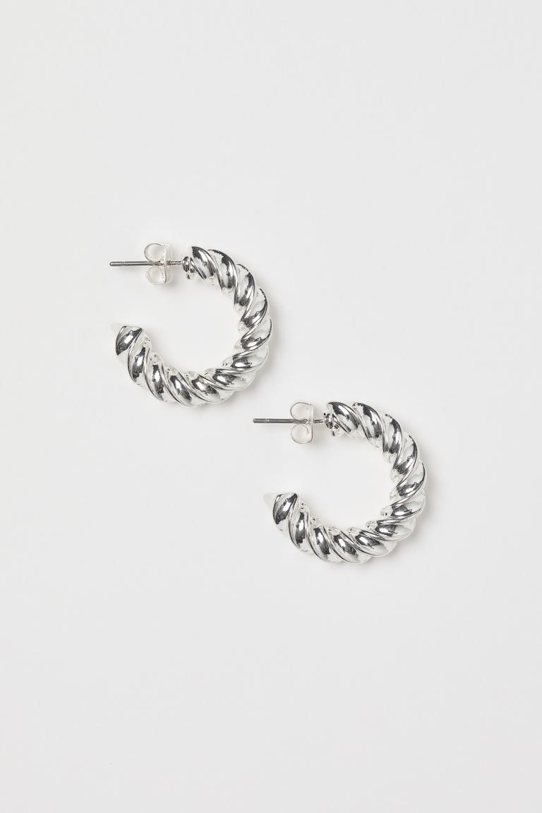 Ein Paar gedrehte runde Ohrringe aus zurückgewonnenem Zink. | H&M (DE, AT, CH, DK, NL, NO, FI)