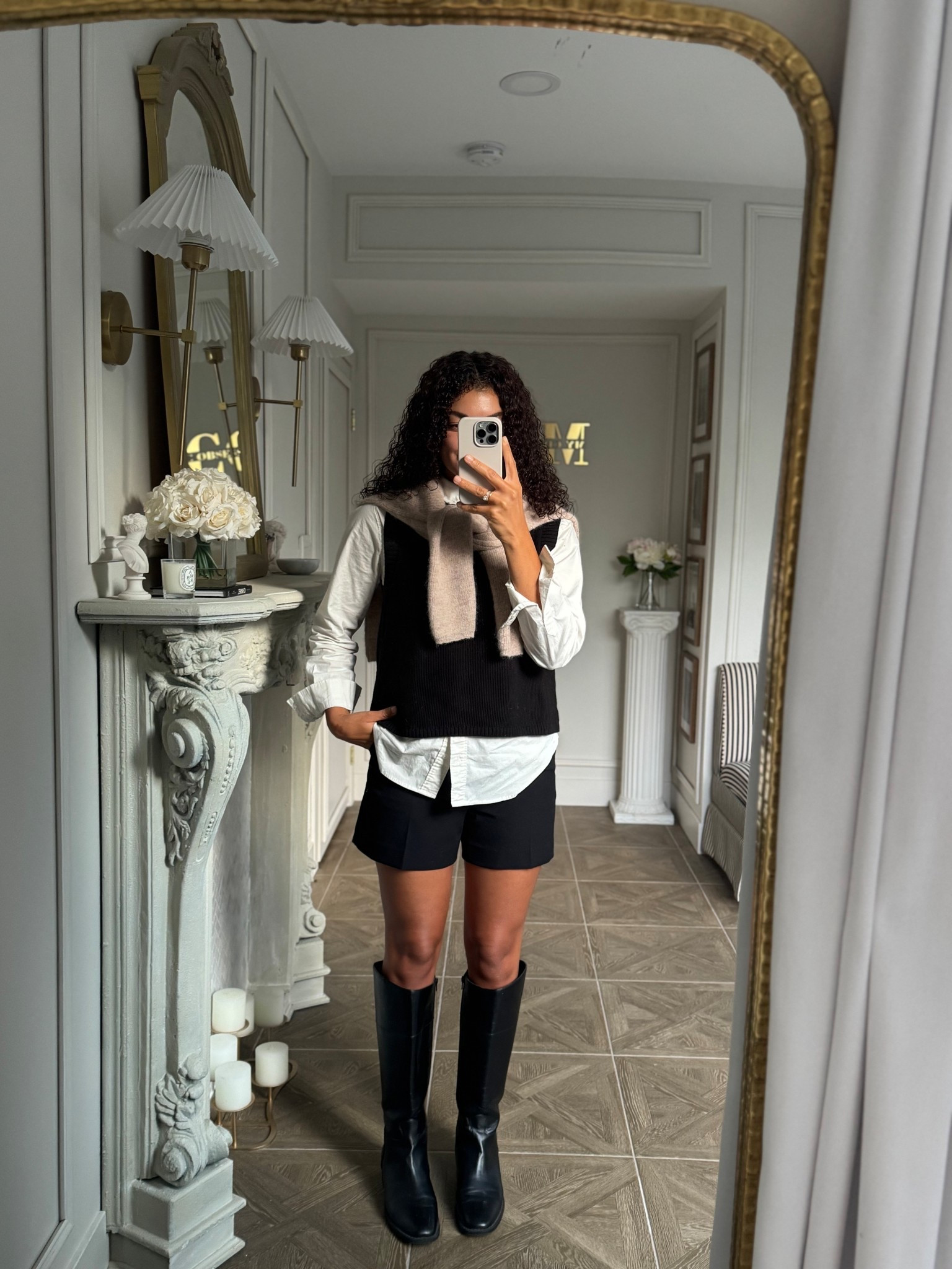 Early fall outfit: white button up layered under a sleeveless sweater, black shorts, knee high boots, and a draped sweater to top it off 

#LTKStyleTip #LTKSeasonal