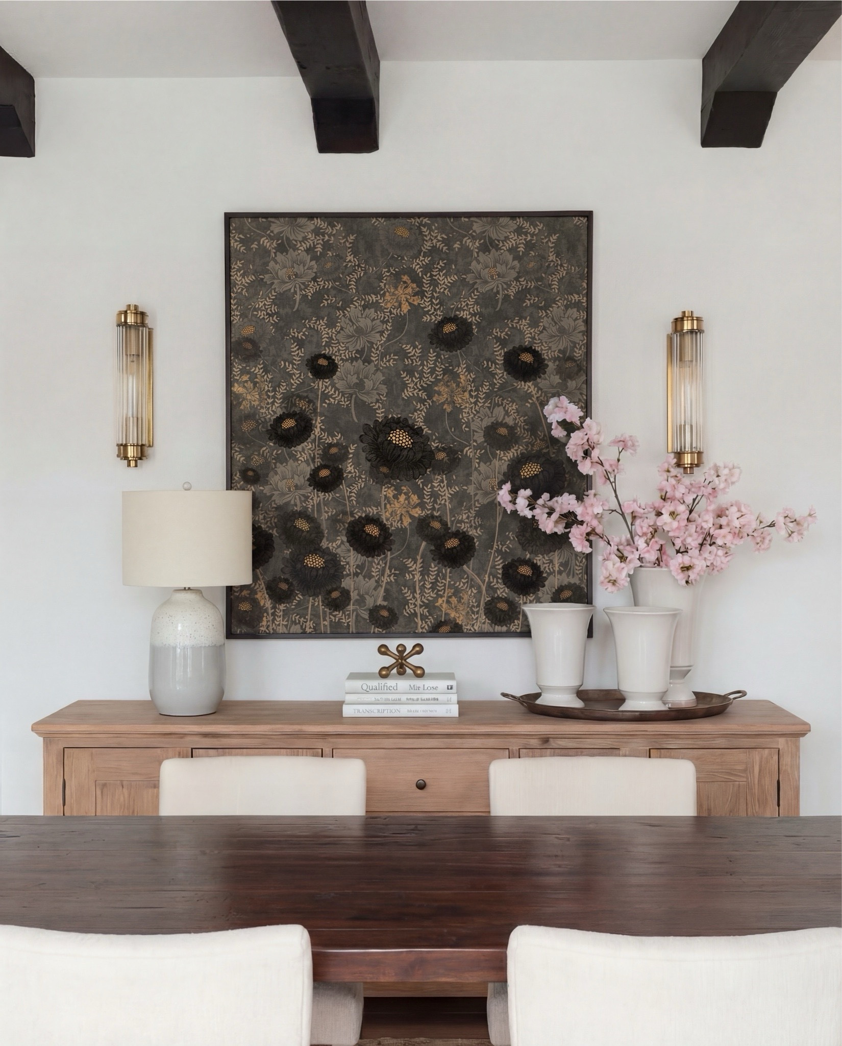 Shop the Look:
• Dark wood pedestal dining table
• Cream upholstered dining chairs with light wood legs
• Large neutral area rug with charcoal medallion pattern
• Black arched display cabinet / hutch
• Light wood sideboard / buffet cabinet
• Large ceramic floor vase (neutral tone)
• White ceramic bowl with white florals (peonies or roses)
• Pink faux cherry blossom stems in white vase
• Neutral ceramic table lamp with white shade
• Tall brass wall sconces with glass detailing
• Framed botanical artwork (set of four)
• Dark abstract wall art (large statement piece)
• White decorative vases (assorted sizes)
• Light linen curtains

#LTKHome #LTKSaleAlert