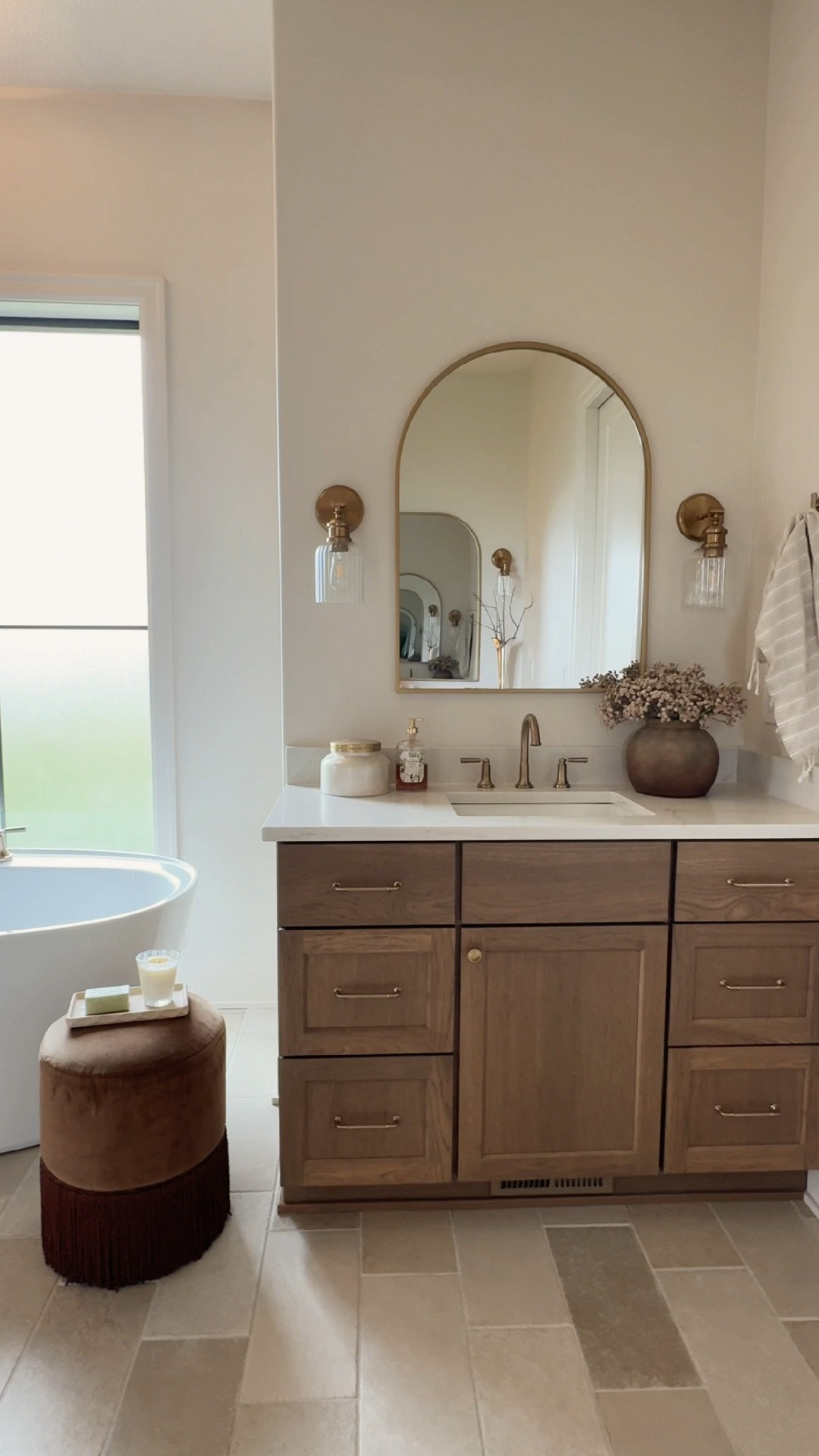 Three details that elevated our primary bathroom vanity 🤎

The arched mirror softens the space, the champagne-bronze faucet adds warmth, and the ribbed-glass sconces bring in just the right amount of character. I linked these details and a few more exact sources from the room below!

#LTKHome #PrimaryBathroom #BathroomVanity #ModernTraditional