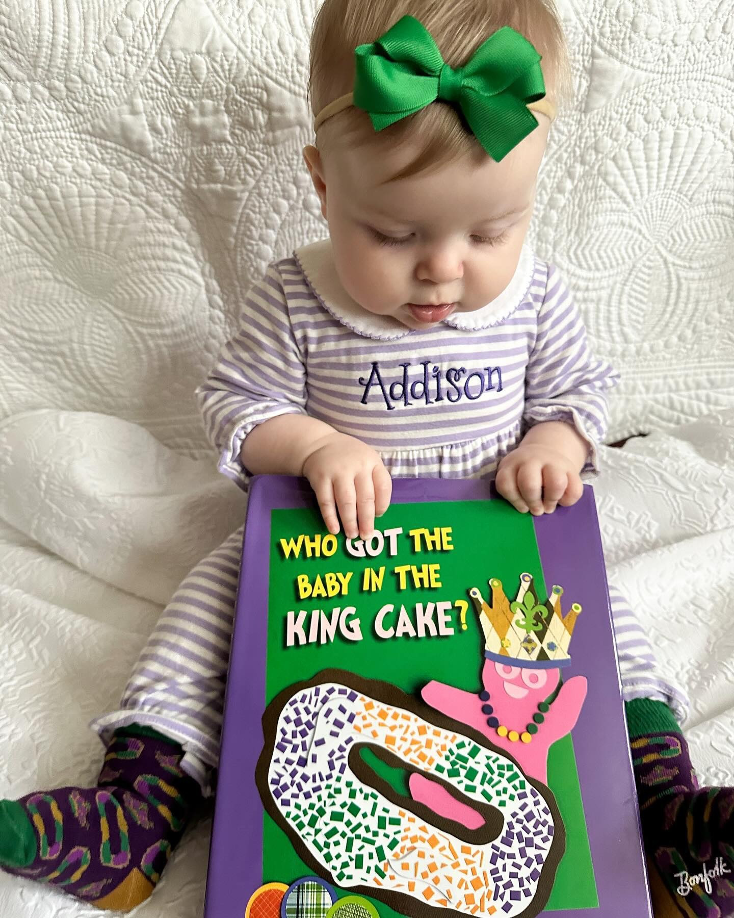 Addison’s #ootd • Can you tell we’re ready for March 4? Cutest little king cake baby I’ve ever seen wearing an outfit from GC, reading a book from Mimsy and wearing socks from Aunt @minzie_mamzie_ 💚💜💛