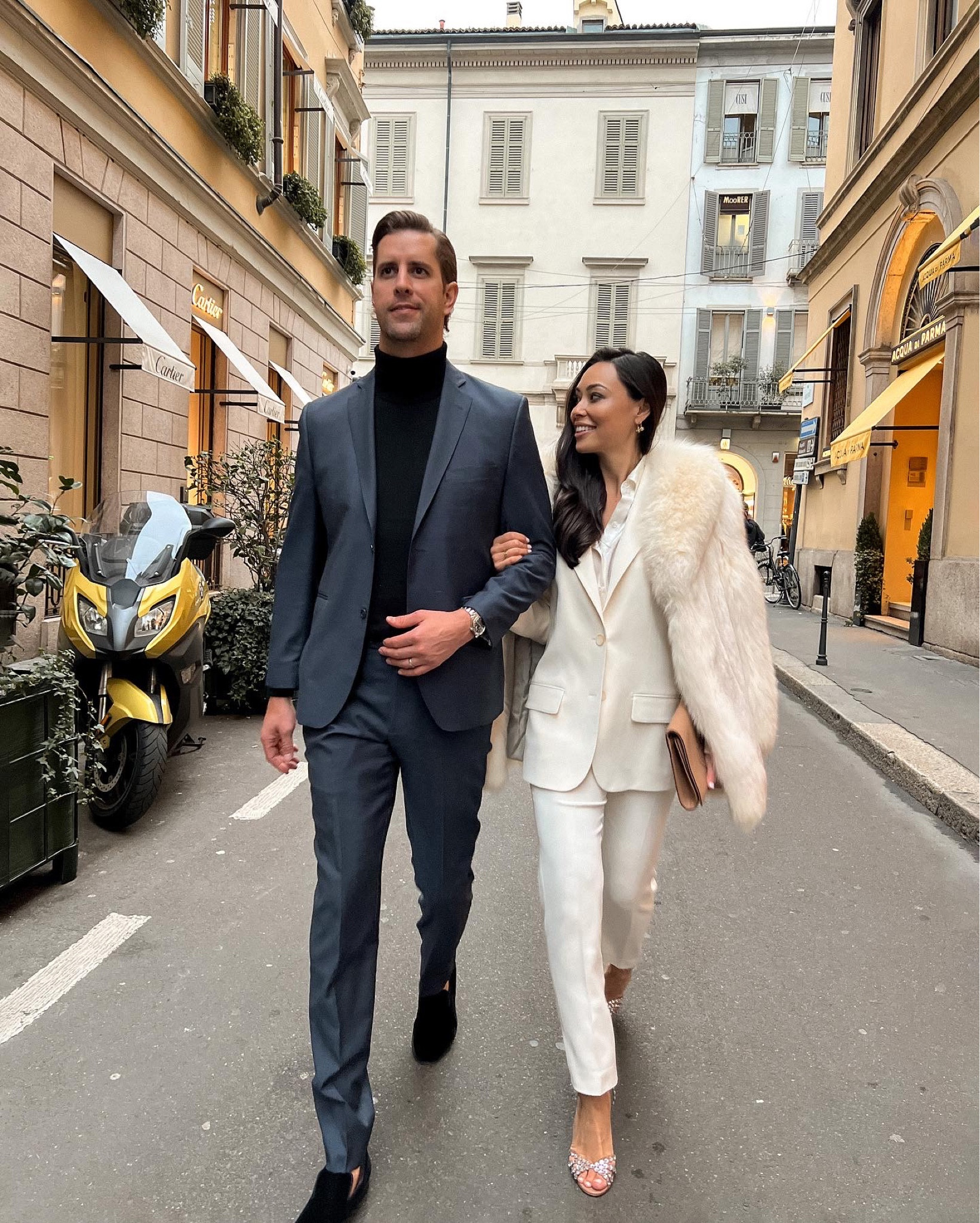 Kat Jamieson wears an ivory pant suit with a vintage fur coat and Aquazzura heels with her husband wearing a navy blue suit and turtleneck. His and hers, formal, dressy, workwear, cocktail, trousers, heels, special occasion. 

#LTKworkwear #LTKshoecrush #LTKmens