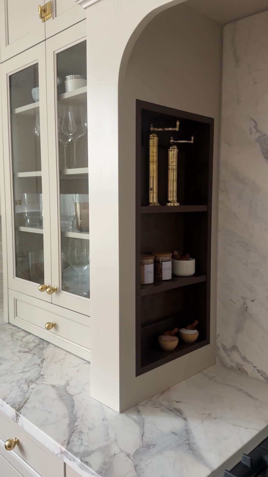 I often have clients ask if they really have to style their open shelves or glass-front cabinets—and how to make them look intentional, not cluttered. When @charlottesafavi produced & styled this kitchen, we brought our go-to pieces and created a vignette that blends form and function beautifully.
The key? Layering textures, mixing heights, and styling in groups of 2–3. We used a mix of materials—wood, marble, glass, brass, and ceramic—to create warmth and depth. Everyday items like olive oil and salt + pepper pinch pots sit between sculptural pieces and vintage-inspired finds.
Varying sizes and heights keeps it from feeling flat, and makes even the most practical kitchen items feel elevated. ✨

Kitchen styling, alcove styling, kitchen shelf styling, alcove hood 



#LTKHome