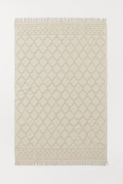 Large rug in woven fabric made from recycled cotton with a tufted, same-color pattern. Tassels at... | H&M (US)