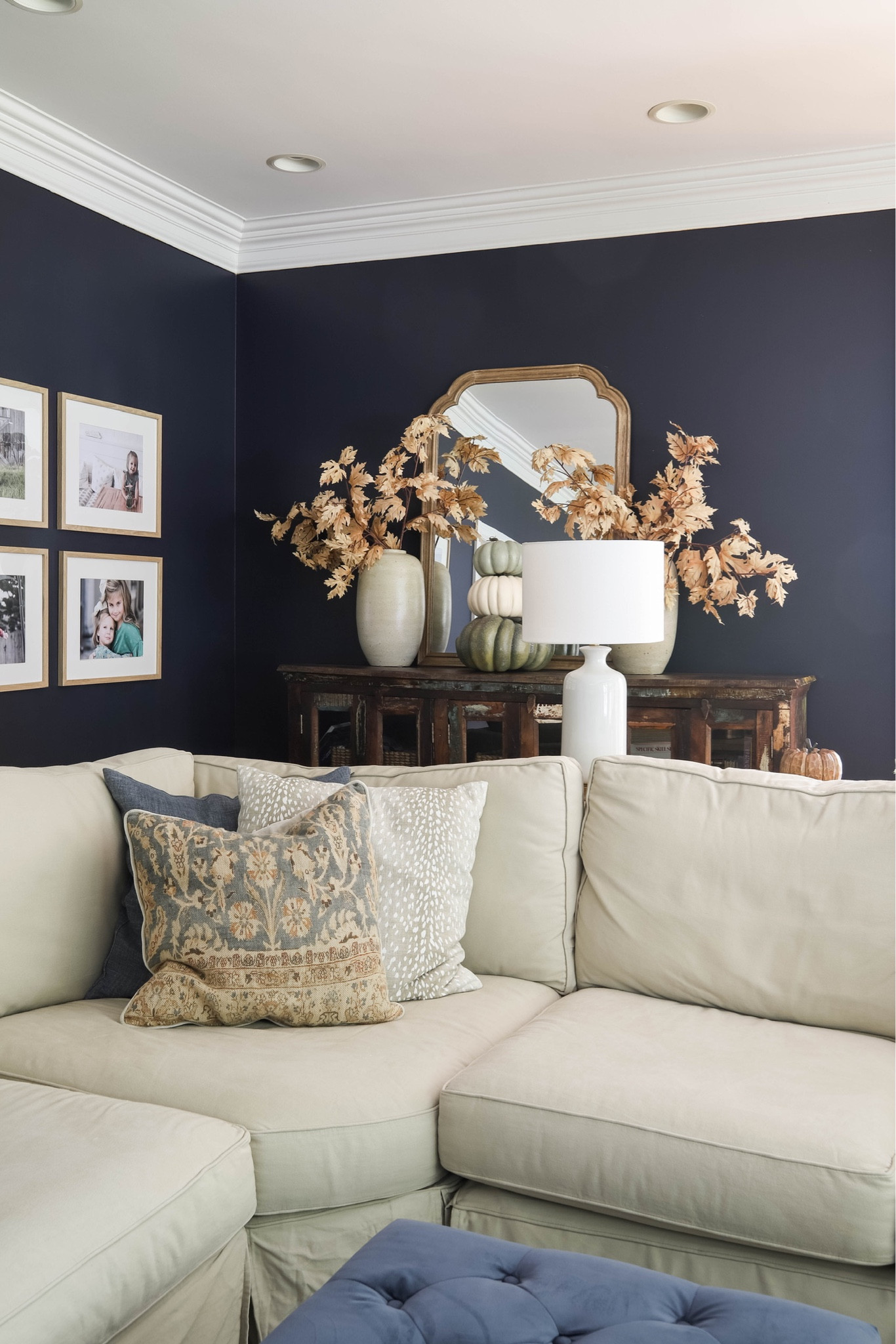 Favorite Fall Decor in my living room, includes: wood framed mirror, bleached oak leaf stems, artisan vase, white lamps, pottery barn PB comfort sectional, gallery wall frames, blue linen pillow covers, Palna pillow cover, leopard print pillow cover, navy ottoman.

#LTKSeasonal #LTKhome