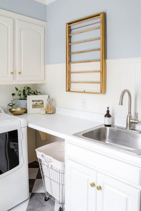 My laundry room is both lovely and functional with a wall-mounted drying rack, a rolling, under-the-counter clothes hamper, and a deep sink with a tall faucet. I am still enjoying the vinyl floor tiles and bead board walls.

#LTKHome