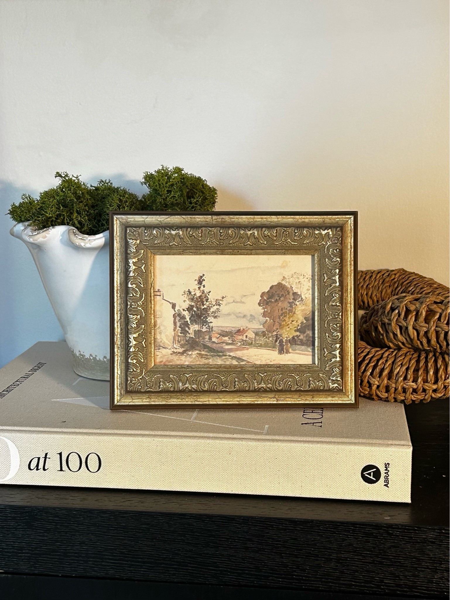 Styling a shelf with framed art, a book, a rattan link chain, and a ruffle planter.

#LTKsummer #LTKhome #LTKcanada