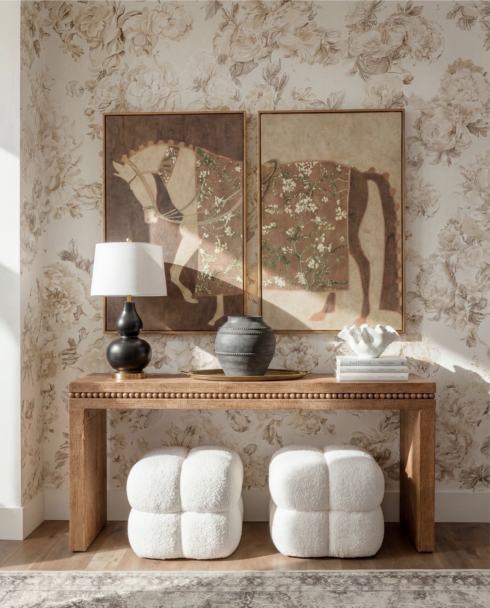 Shop the Look:
• Neutral floral wallpaper (beige + taupe tones)
• Solid wood console table (warm oak finish)
• Beaded edge console table detail
• Framed vintage-style art prints (earthy brown tones)
• Brass picture frames
• Black ceramic table lamp with white shade
• Decorative table tray (antique brass)
• Stone or ceramic vase (charcoal gray)
• Sculptural white bowl (organic shape)
• Coffee table books (neutral covers)
• Bouclé cube ottomans (ivory)
• Light wood flooring
• Vintage-style area rug (muted beige + gray)
• White baseboards and trim

#LTKSaleAlert #LTKHome