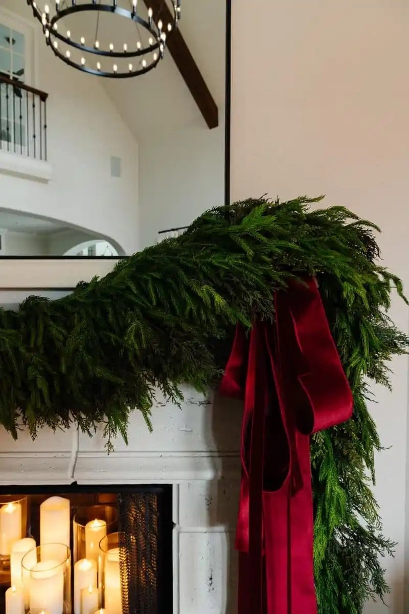 A mixture of Norfolk Pine and a couple of my old garlands make up this lush look. The 4” wired velvet ribbon and 1” velvet ribbon are the most beautiful burgundy shade. Loop several long strips together with a clip for this easy ribbon look on the fireplace mantle.

All the candles in the fireplace are battery operated LED on timers 🕯️ 





#LTKHome #LTKSeasonal #LTKHoliday