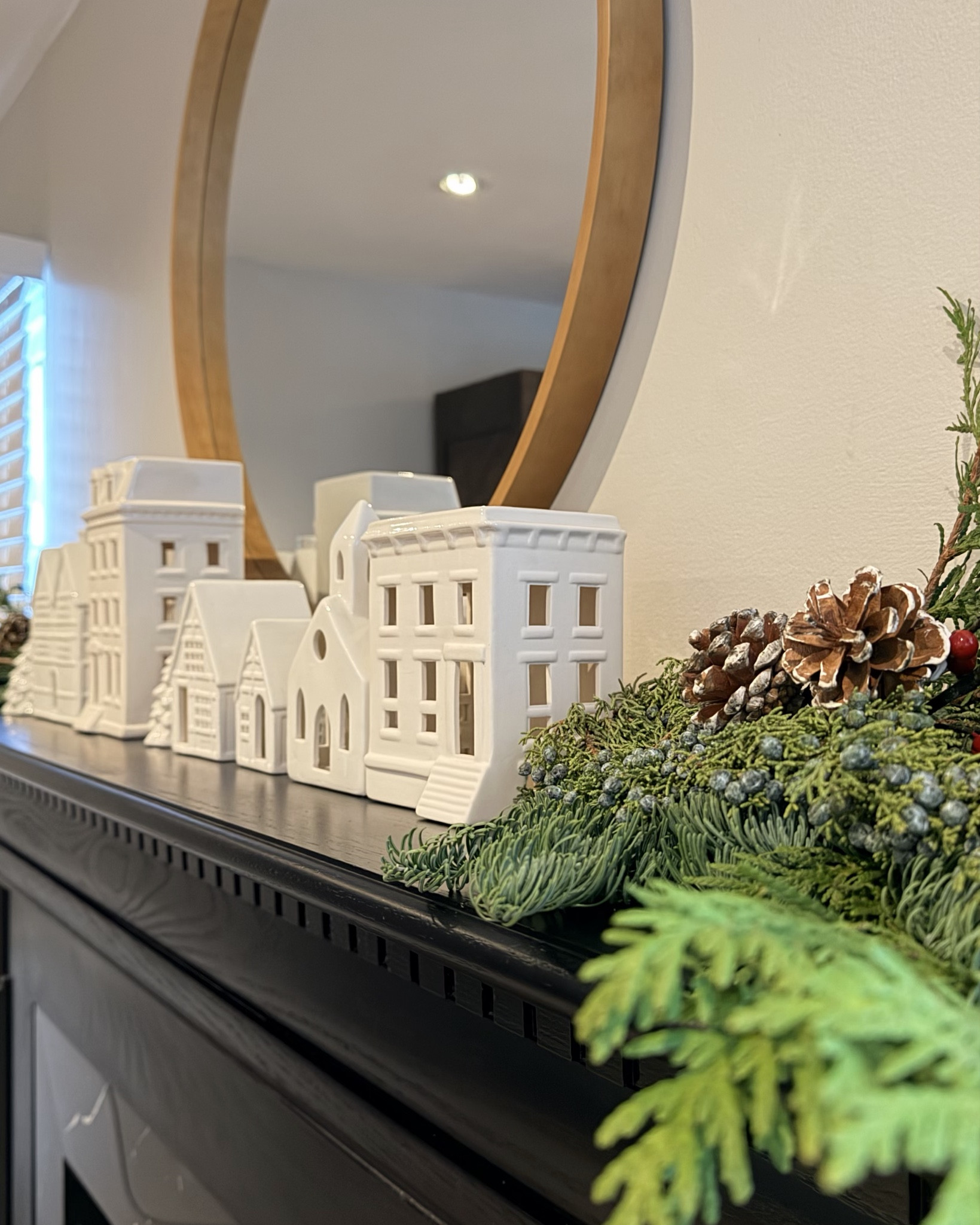 Holiday mantel decor that feels cozy, simple, and timeless. I styled this mantel with a soft evergreen garland, ceramic village houses, pinecones, and warm candlelight layered in front of a round mirror for added height and glow. A classic holiday look that works from Thanksgiving through Christmas and makes the whole room feel inviting.

#LTKHoliday #LTKSeasonal #LTKHome
