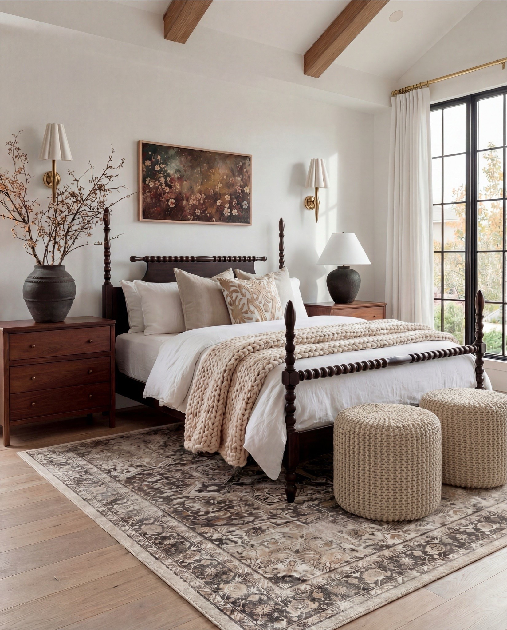 Shop the Look: Bedroom Refresh
• Dark wood spindle bed frame
• White cotton duvet cover + pillow shams
• Neutral patterned area rug
• Cream Chunky knit throw blanket (warm beige)
• Woven knit poufs ottomans (bedside or bench seating)
• Wood nightstands with brass knobs
• Black ceramic table lamps
• White tapered lamp shades
• Brass wall sconces
• Framed floral wall art
• Textured accent throw pillows (neutral tones)
• Ceramic decorative bowl (white sculptural style)
• Wood bead garland with tassel
• Natural wood ceiling beams
• Light wood flooring

#LTKHome #LTKSaleAlert