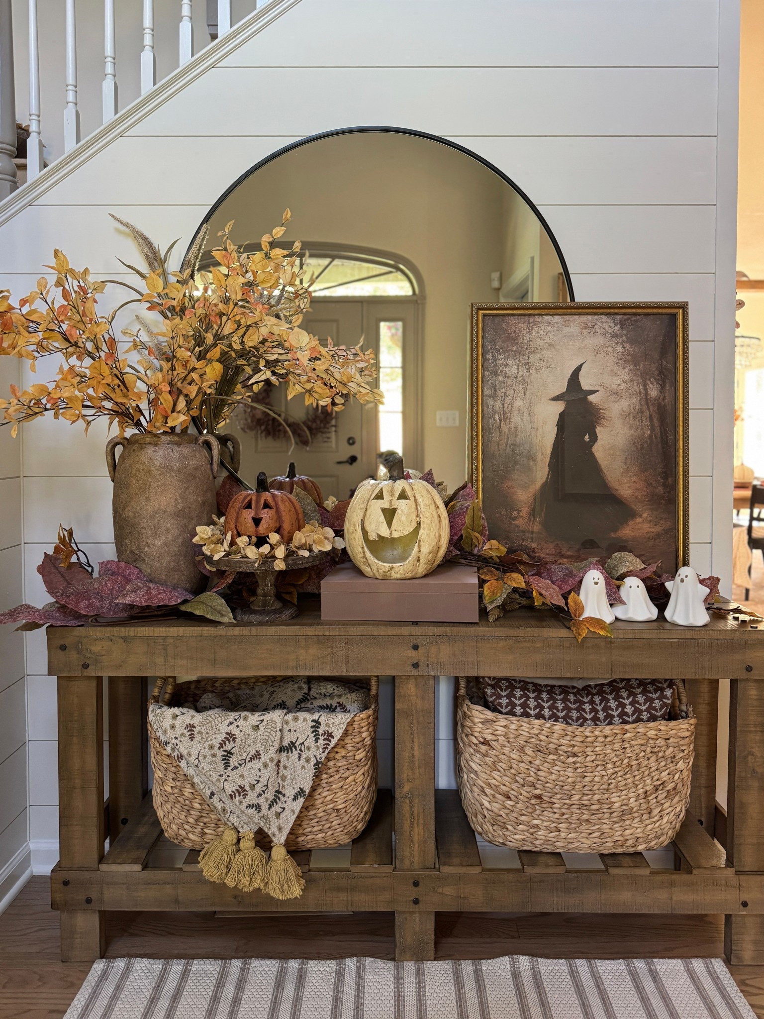 Halloween/fall entry table and decor. I’m loving my new moody forest witch print and gold frame. The print and frame are both 20x28. Favorite Jack-o-lanterns, trio of small ceramic light up ghosts, fall garland and new tall 48” golden yellow fall dogwood branches that are currently on sale! All being displayed on our 64” entryway table with two tall narrow baskets underneath and 42” round wall mirror. Vase is from Joon Loloi and I’m unable to link  

#LTKFindsUnder50 #LTKSeasonal #LTKHome