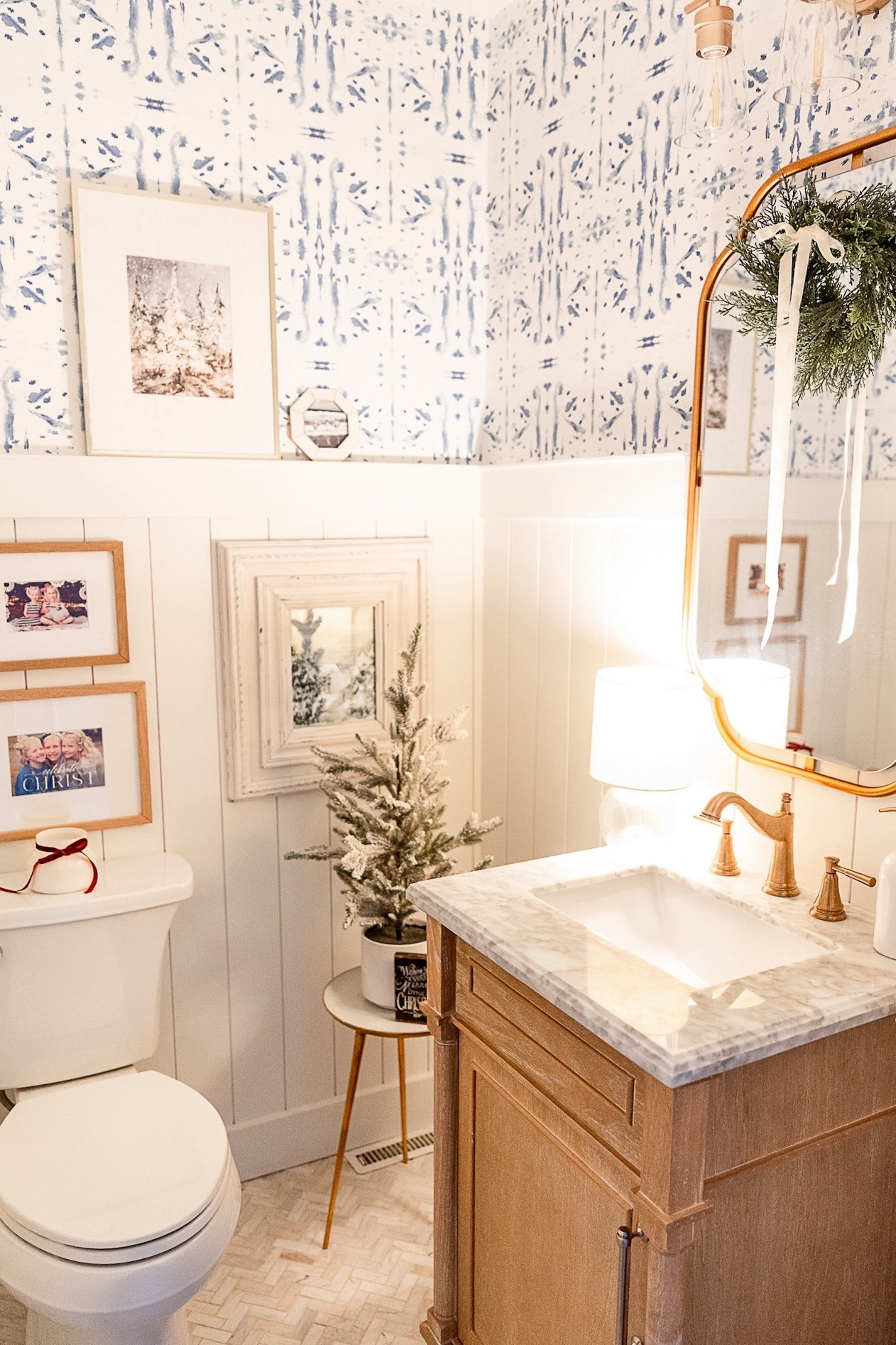 Powder room decor
Bathroom decor 
Christmas decor 
Aberdeen single sink antique oak vanity with Carrara marble top
Geometric shape vanity mirror
Gold vanity mirror
3 light bath light fixture
Angora herringbone mounted mosaic tile
Bathroom floor tile
Kohler toilet
Soap dispenser
Winter art prints
Cedar wreath 
Mini wreath 
Capri blue candle 

#LTKHome #LTKHoliday #LTKSeasonal