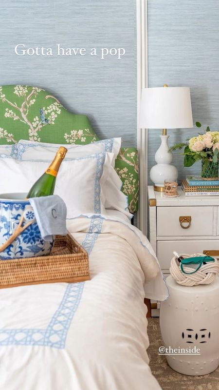 Bedroom details with a beautiful upholstered chinoiserie headboard, cane border duvet and monogrammed pillows, embroidered scalloped edge sheets, white goird lamps with USB hookups for devices, blue coastal grasscloth wallpaper, breakfast tray, blue and white champagne bucket, coffee table design books, wrapped glassware, white garden stool

#LTKFind #LTKsalealert #LTKhome