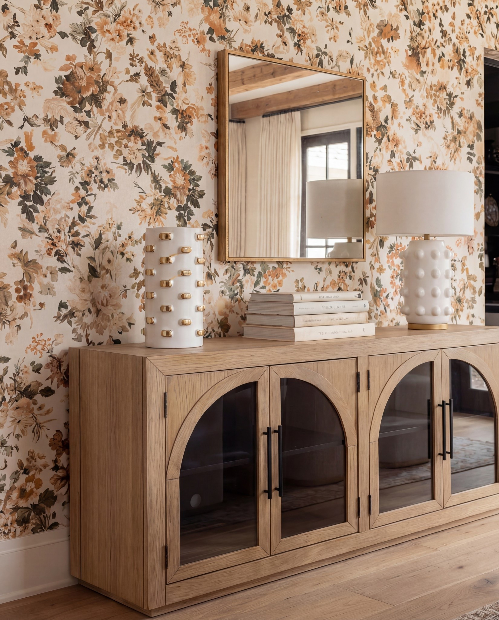 Shop the Look:
• Warm oak dining table
• Curved ivory dining chairs (brass base detail)
• Brass + globe statement chandelier
• Soft floral wallpaper (warm neutrals + terracotta)
• Oak sideboard with arched glass doors
• Textured ceramic table lamps + decor
• Neutral vintage-style area rug
• Gold trays + candle set
• White ceramic serving bowl

#LTKSaleAlert #LTKHome #LTKFindsUnder100