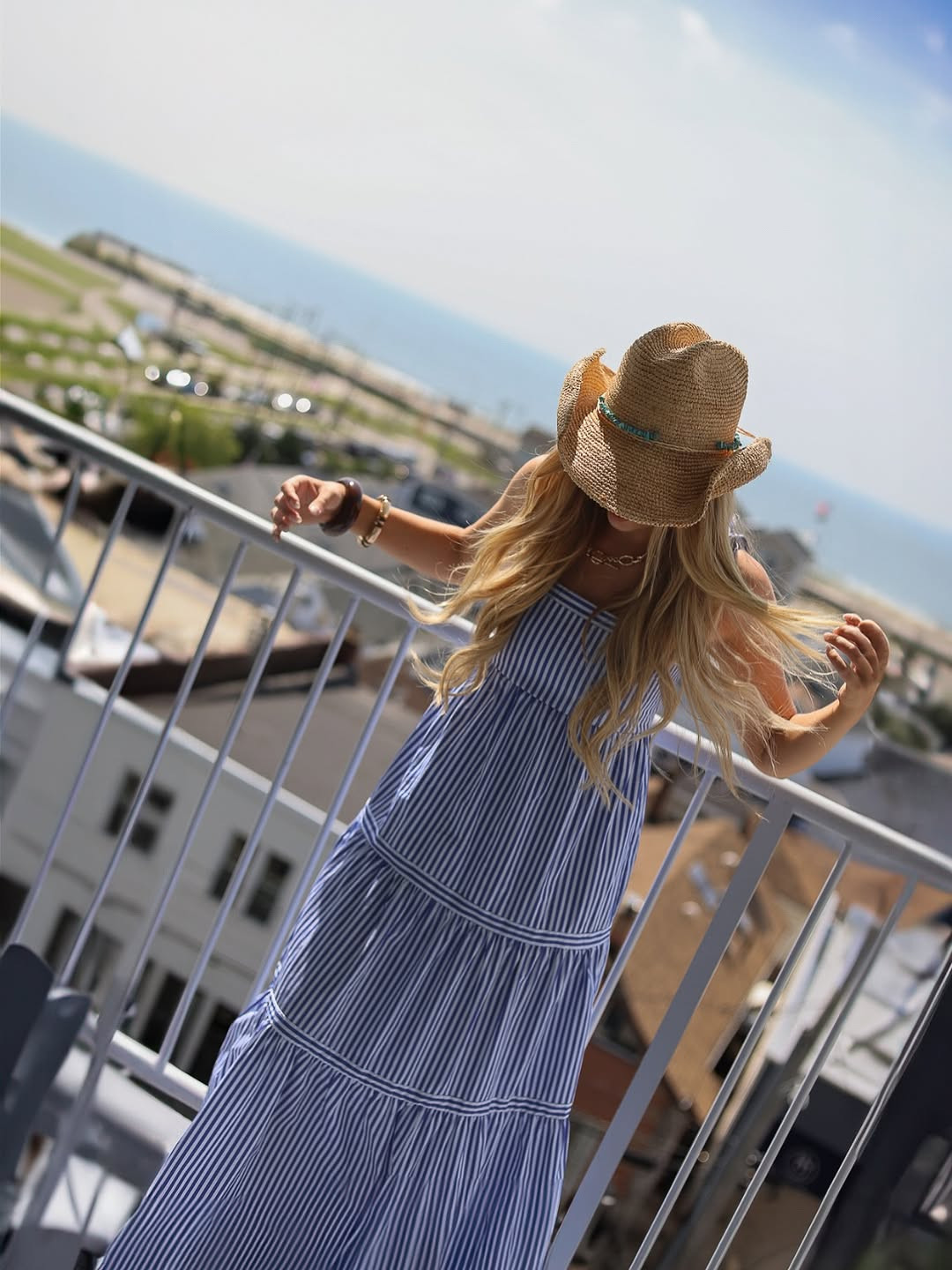Coastal charm. This effortless summer look features a blue and white striped tiered maxi dress paired with a woven straw cowboy hat and gold jewelry. #CoastalGrandmother #SummerDress #LTKtravel 

 #LTKdayinmylife #LTKgrwm #LTKootd