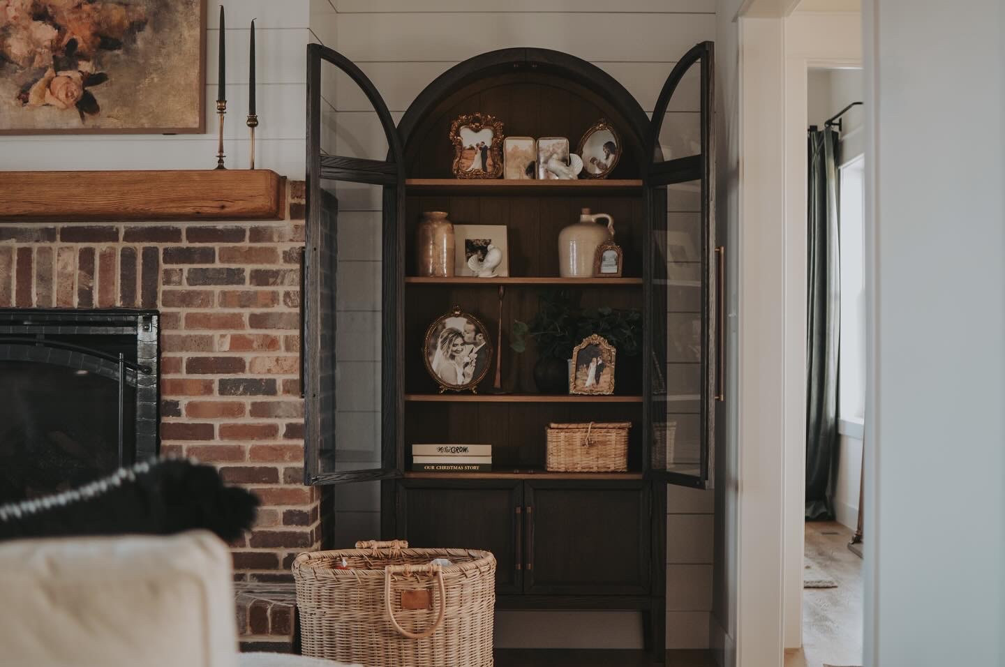 I finally made the jump & purchased the arch cabinet I’ve been eyeing! I wanted a space to display our photos, special items, & other curiosities we may gather over the years. With a little closed storage below, it’s a perfect addition to our main living room. 

I originally planned for it to be in the dining room, but I didn’t feel like it belonged there once we got it home. It fit perfectly in the fireplace nook that needed a little love anyway! 