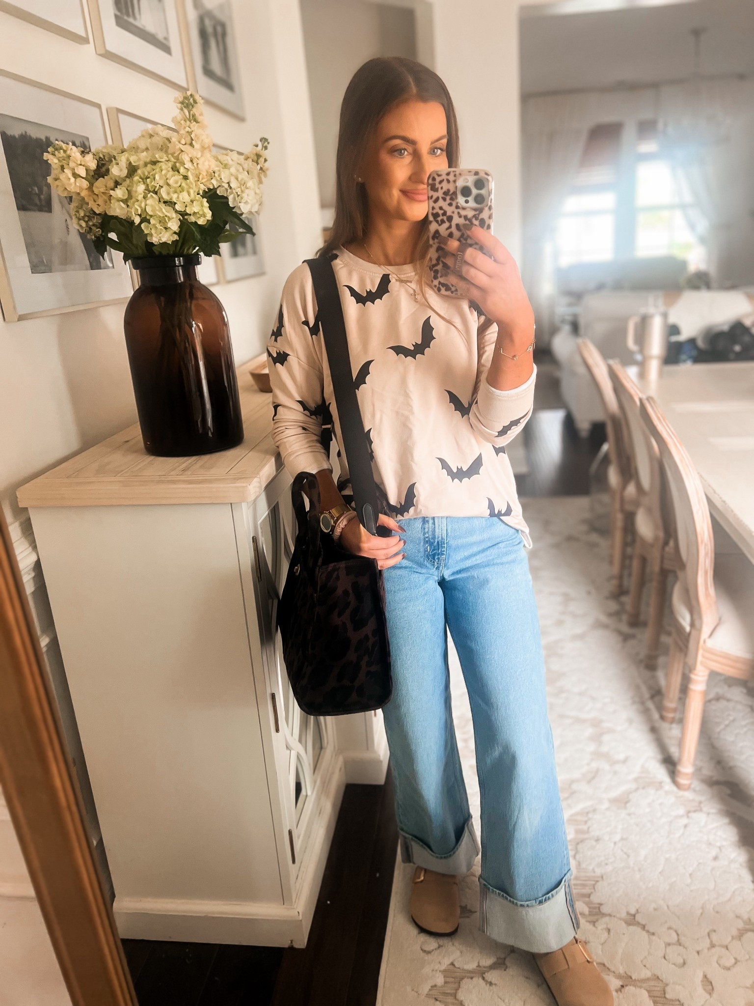 Neutral halloween sweatshirt womens-medium
High waisted folded jeans
Dark leopard Coach tote bag
Brown and gold clogs 
Gold pedometer watch 