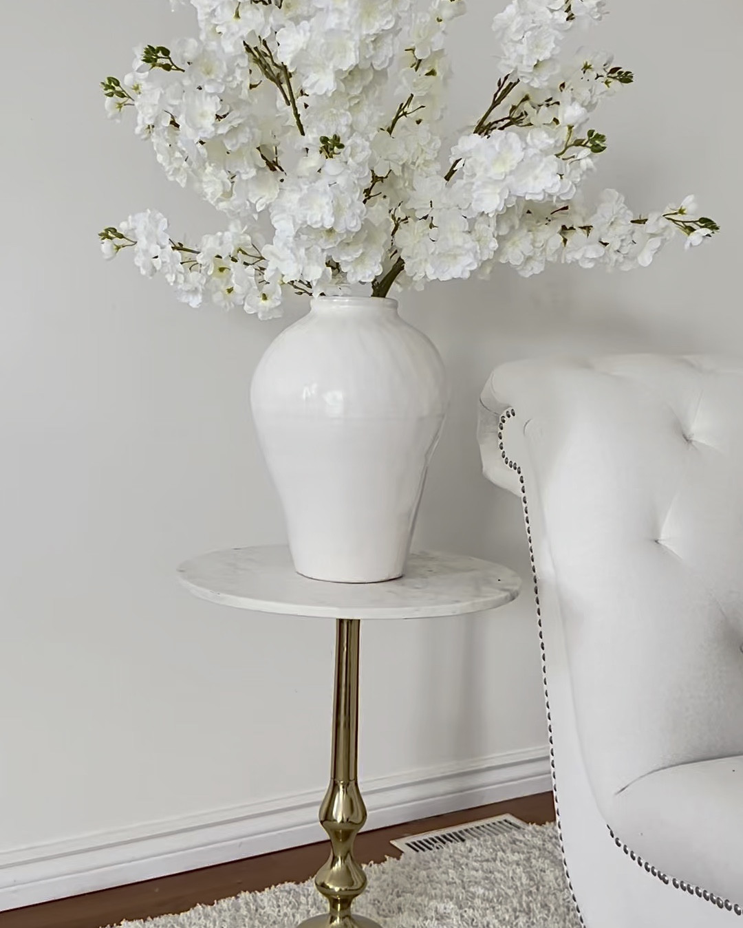 Beautiful decorative accessories to style in your home such as a ceramic vase, cherry blossoms, side table, chaise lounge, throw, decorative pillows and a shag area rug. 

#LTKHome
