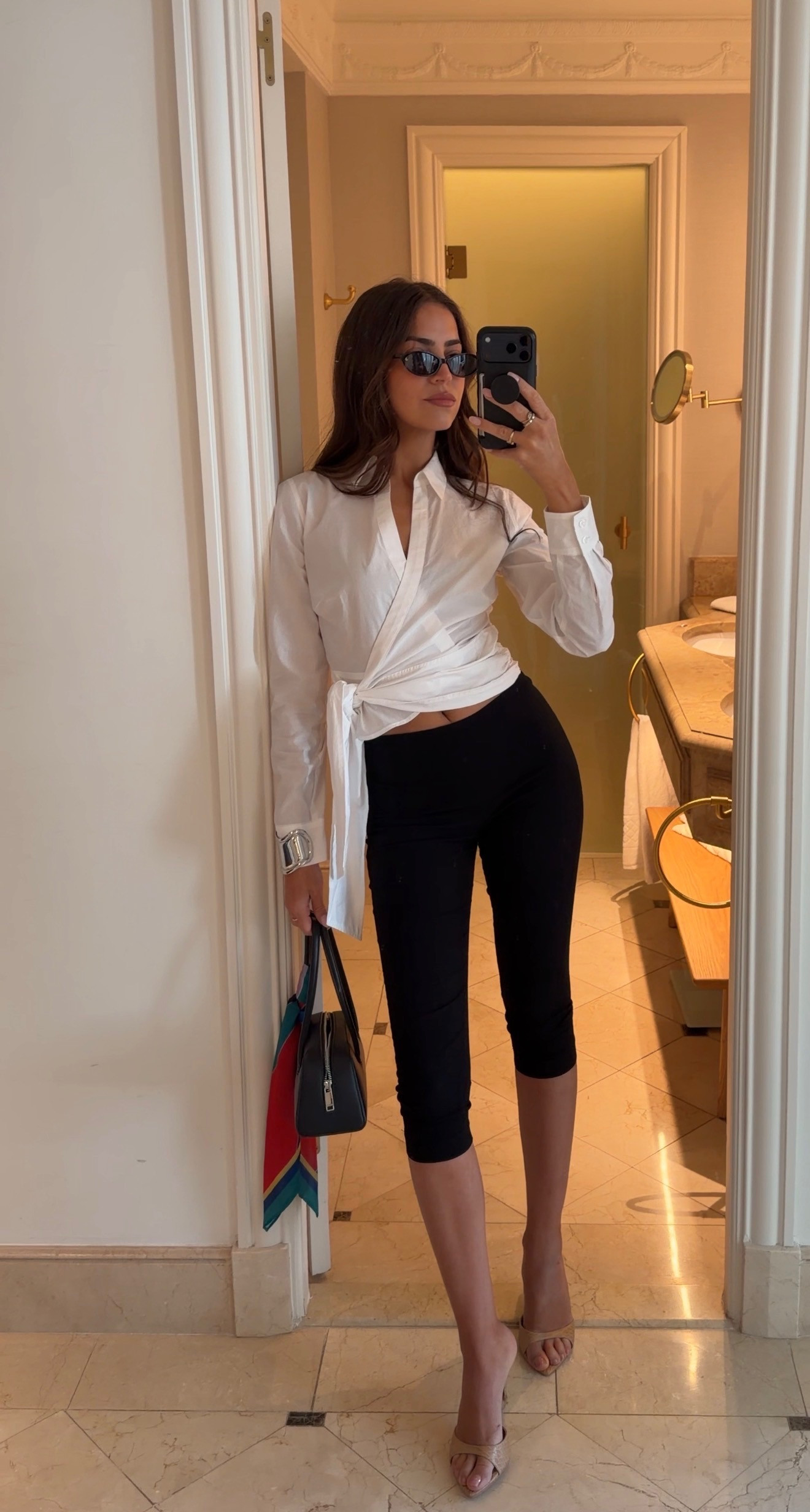 Summer outfit details 🤍 The wrap top is from Hill House Home and paired with black capri pants for the chicest effortless summer look. Perfect for summer dinners, Europe outfits, date nights, and elevated everyday style. Finished with kitten heels, mini bag, and sunnies!

Summer outfits
Vacation outfit inspo
Capri pants
Nude heels 

 #LTKgrwm #LTKootd #LTKSeasonal