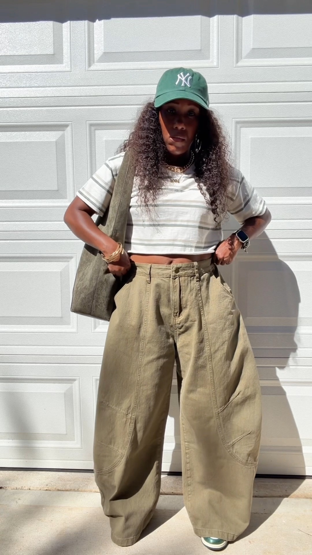 How I style olive green baggy barrel jeans with a green and white stripe shirt. J styled this casual outfit with a green faux suede hobo bag and green and white Nike dunk low vintage green sneakers