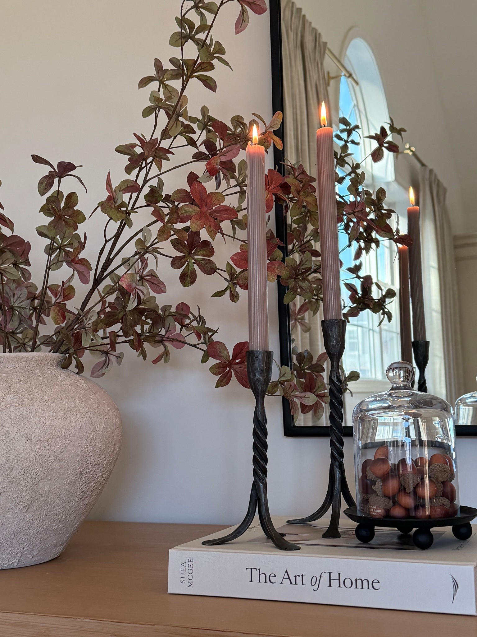 Such pretty candle holders. I really like using two different sizes. This mirror is also a favorite and such a great size. Wall gallery, console styling, home decor, living room decor, black mirror, arched mirror.

#LTKStyleTip #LTKHome #LTKSeasonal