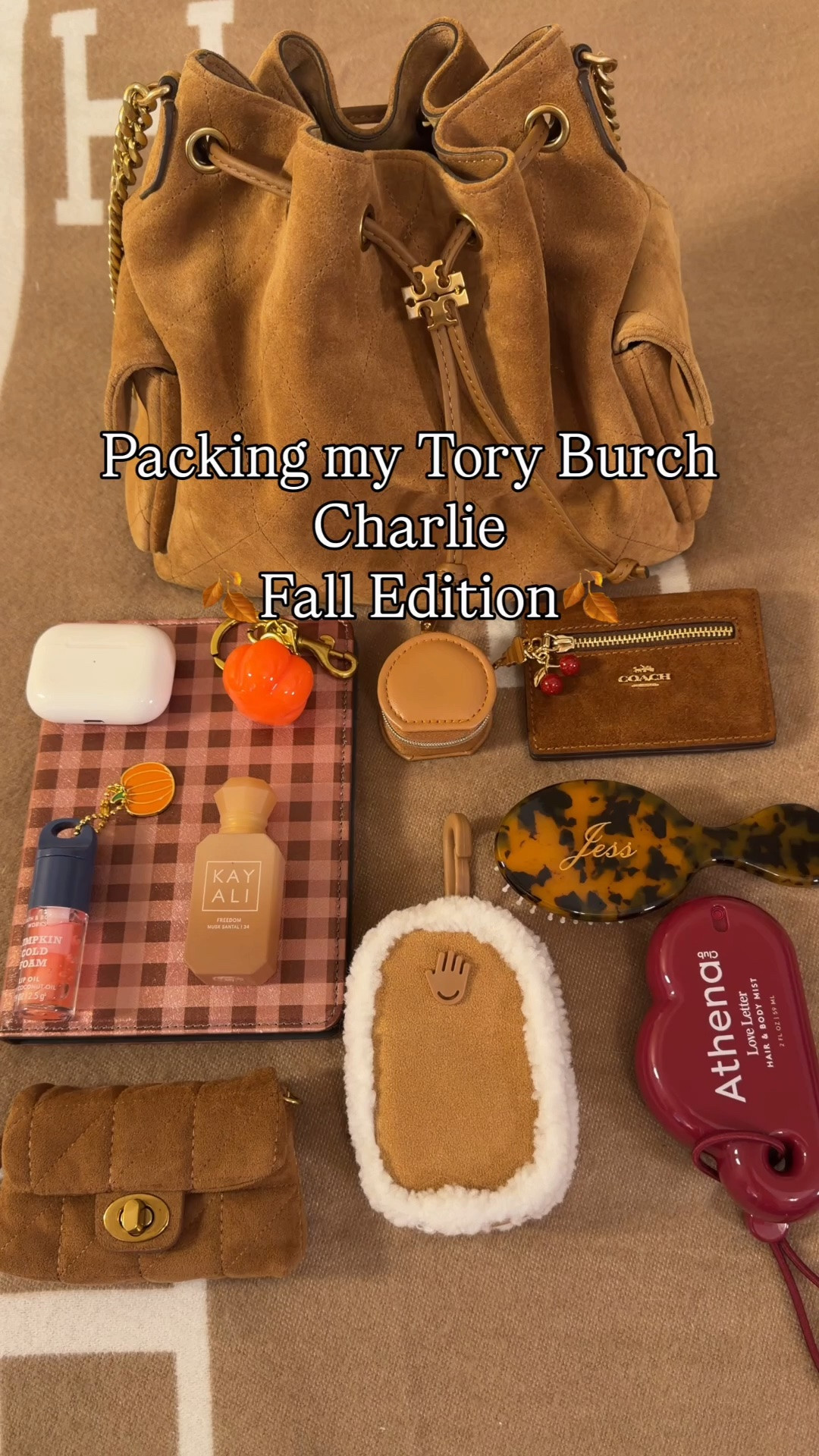 What’s in my Tory Burch Charlie Drawstring bag for fall 🍂 Comment SHOP & I’ll dm you the links 🤎

What’s in my bag:
Tory Burch suede Charlie drawstring bag
Fall plaid kindle case from amazon
Suede Coach outlet wallet
Clear kisslock pouch
KayAli mini perfume
Bath and body works pumpkin cold foam lip oil 
Customizable mini brush from Etsy
Athena body and hair mist from Target 
Mini zipper pouch for jewelry 
Mini turnlock pouch charm from Target 
Shearling touchland case
Touchland hand sanitizer
Pumpkin charm from Amazon
