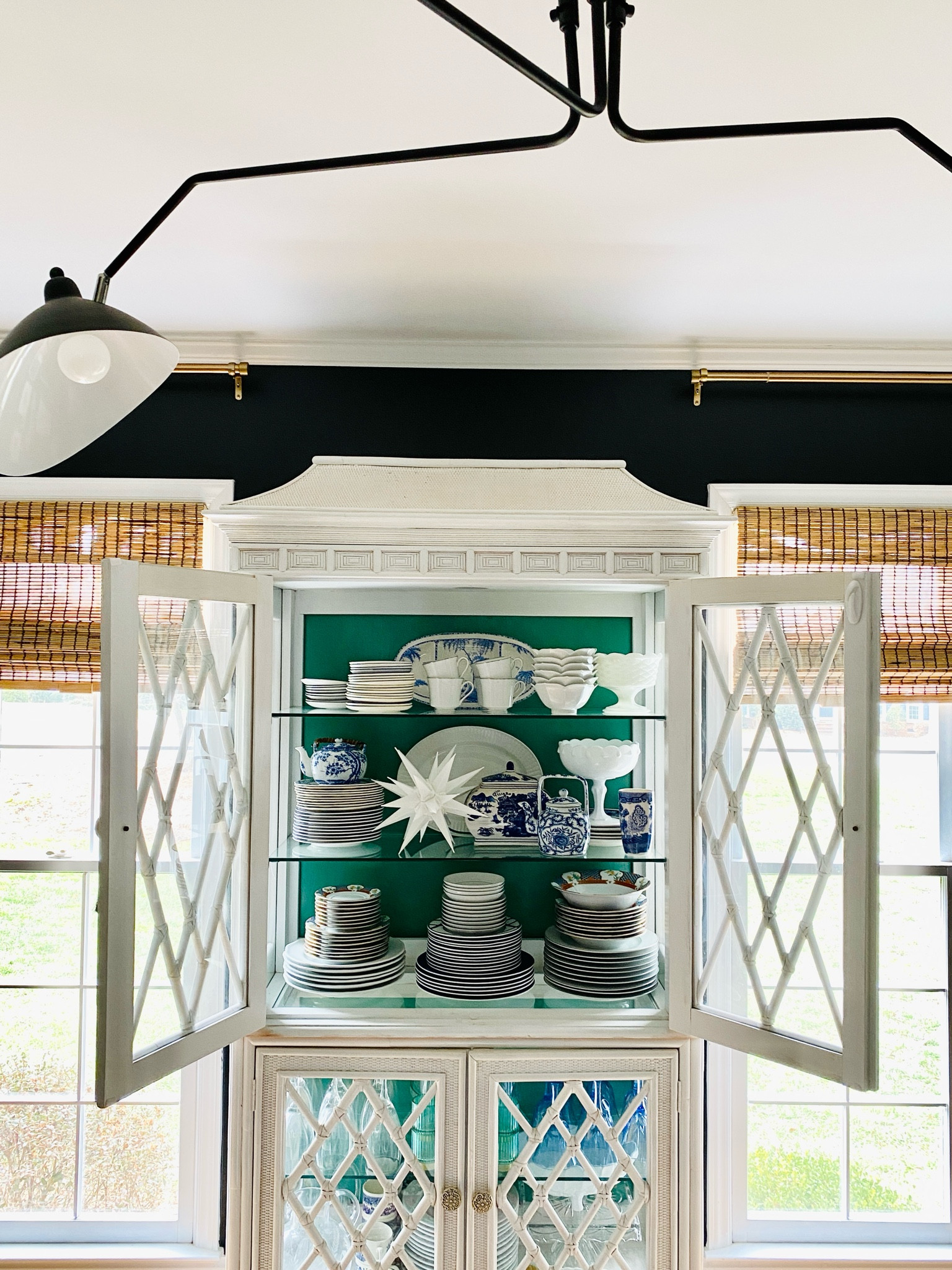 China cabinet styling. 

Moravian star Christmas tree topper, bamboo shades, mid-century modern three light chandelier