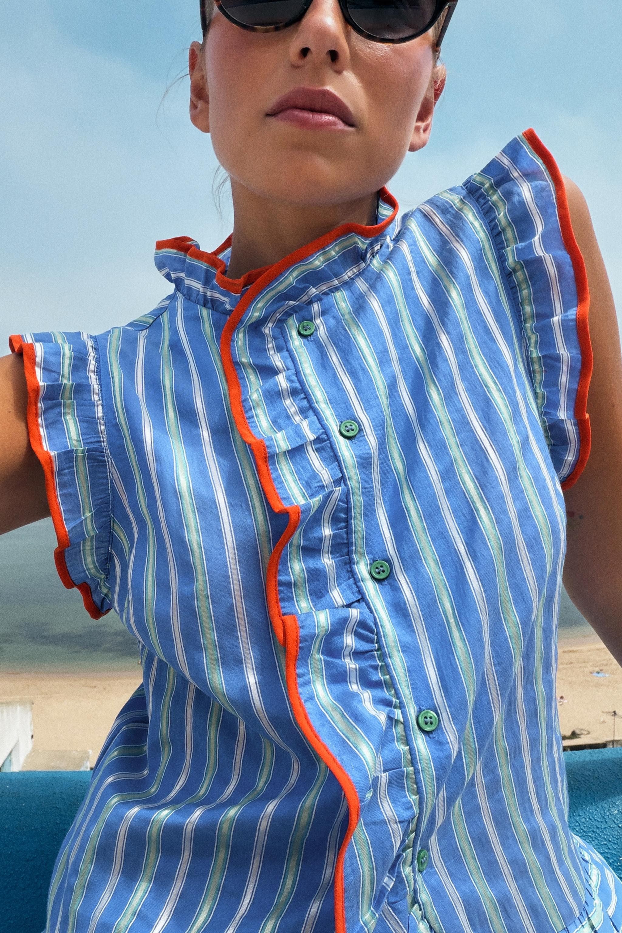 High-neck sleeveless shirt with contrast ruffle trim and piping. Front button closure. | Zara US
