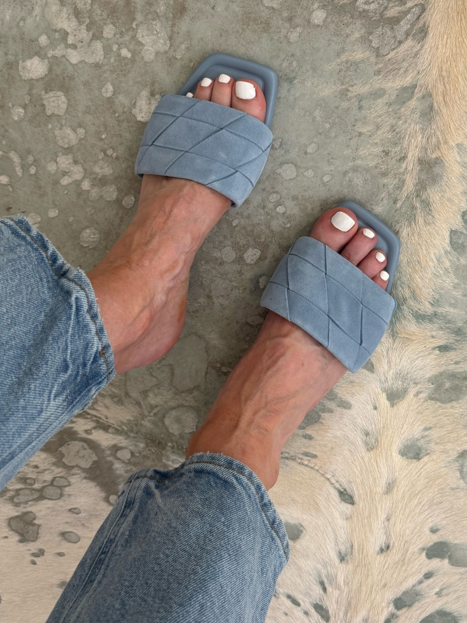 The cutest baby blue suede slides for summer! I love how these designer-inspired flat sandals add the perfect pop of color to a classic white tank and jeans outfit while still feeling effortless and comfortable. I’m wearing a size XS in the tank and size 24 in the jeans. #SummerSandals #CasualSummerStyle #DenimOutfit #LTKOver40 

 #LTKootd #LTKSeasonal #LTKOver40