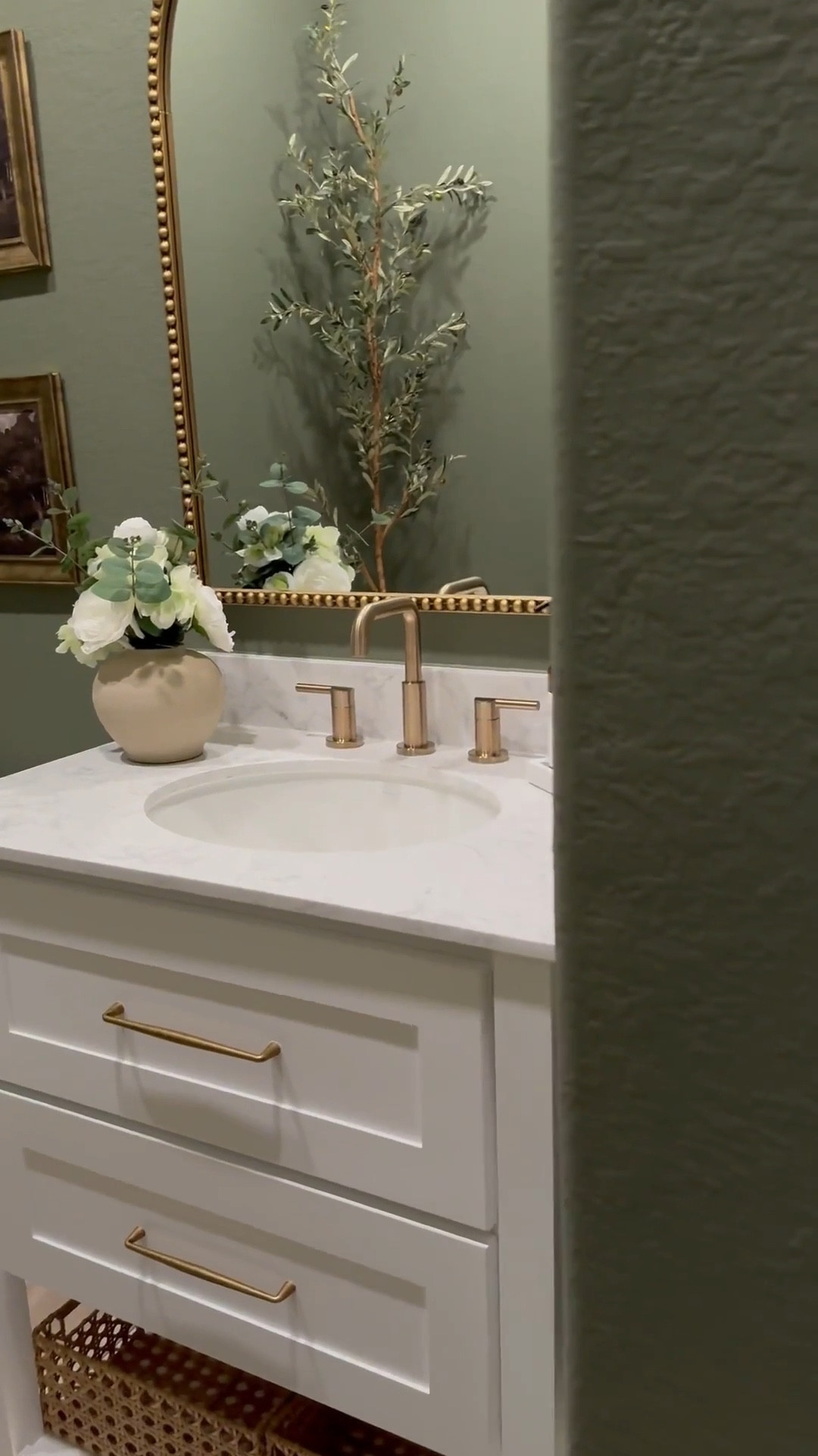 If you’re considering color drenching a room green, I’m telling you, THIS might be the perfect color for you … go for it! 🤍

Walls & Ceiling - flat finish
Baseboards - satin finish

I was apprehensive but I decided to paint the ceiling 😬 …. Surprisingly it made the room feel larger! 

I chose brass finishes to create a vintage feel…, modern vintage perhaps …??? 😆.. 

The mirror is 30x40 inches… 

I added a new light fixture and it now faces upward … which makes that wall feel taller!

I wasn’t in love with this builder grade vanity tbh😆, matter-fact, I wanted to change it… it wasn’t functional …but now i wanna keep it lol 😂… I added brass hardware, cute baskets, led light strips on the bottom and now it’s a whole new unit….. you can even add battery powered/rechargeable/plug in led light strips .. whatever fits your lifestyle 

Ok let’s talk about this stunning planter!!! …. We all love an olive tree don’t we? 😆 … and I wanted something tall and slim… this planter was… perfect plus it added to the moody feeling of the room 🥰

#bathroommakeover #powderroom #powderroomdesign #homedecorideas #beforeafter

#LTKSaleAlert #LTKStyleTip #LTKHome