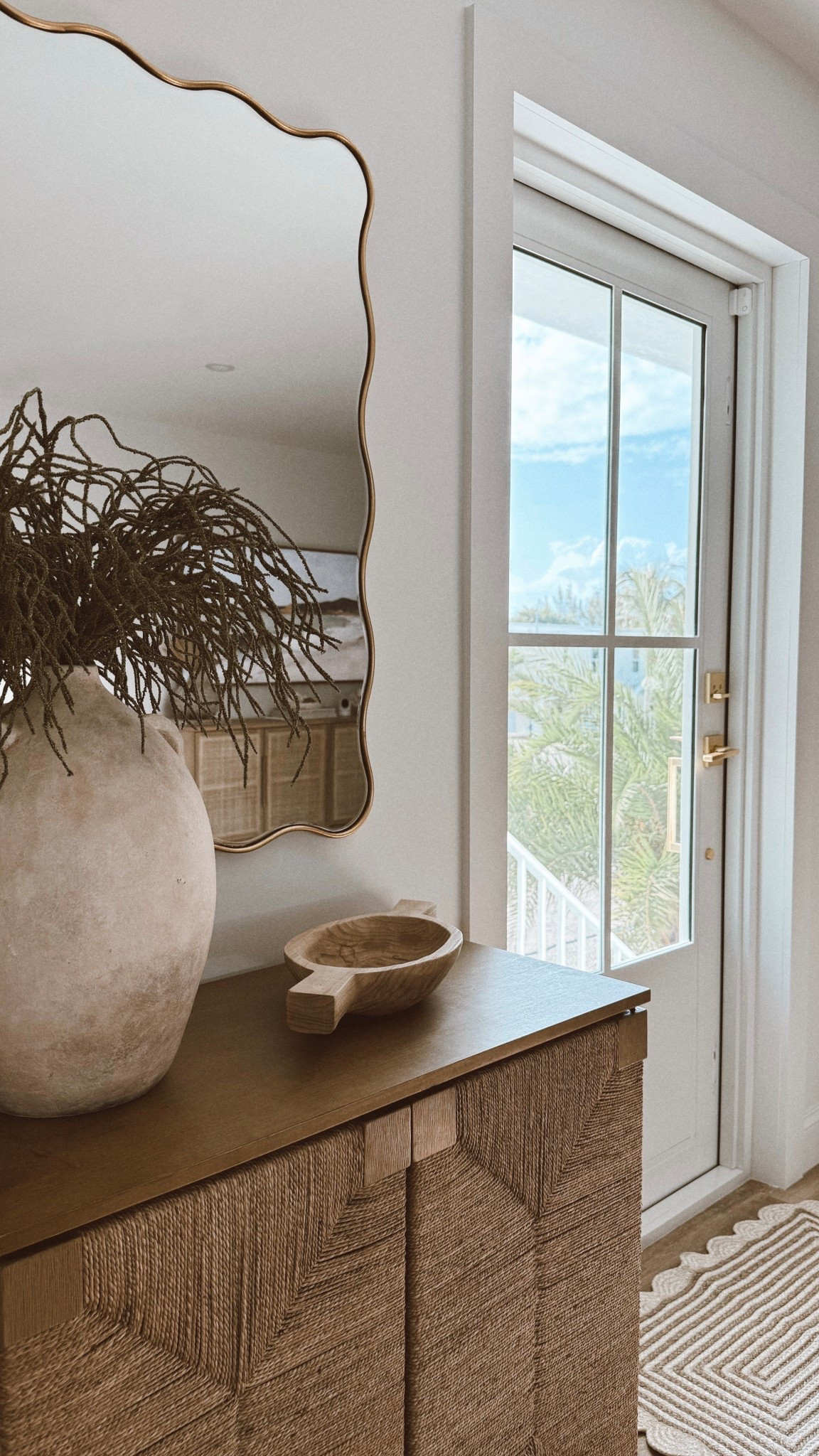 Small entryway cabinet + mirror ✨

#entryway #cabinet #wavymirror #mirror #vanitymirror #rattancabinet #wovencabinet #entrywayrug #homedecor #neutraldecor #vase #jug #entrystyling 

#LTKSeasonal #LTKSaleAlert #LTKHome