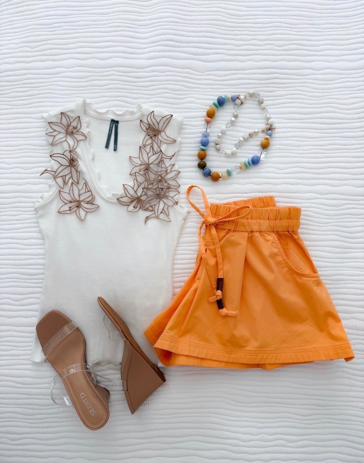 This outfit is such a fun way to add color to your summer wardrobe. The embroidered tank feels elevated and feminine, while the bright shorts bring the perfect pop of color. Finished with clear sandals and a colorful necklace, it’s an easy look for vacations, brunch, or warm weather plans.

Summer outfit, Colorful style, Embroidered tank, Orange shorts, Vacation outfit, Resort wear, Summer fashion, Casual chic style, Statement accessories, Warm weather outfit, Everyday summer look, annabrstyle

#LTKootd #LTKSeasonal #LTKTravel