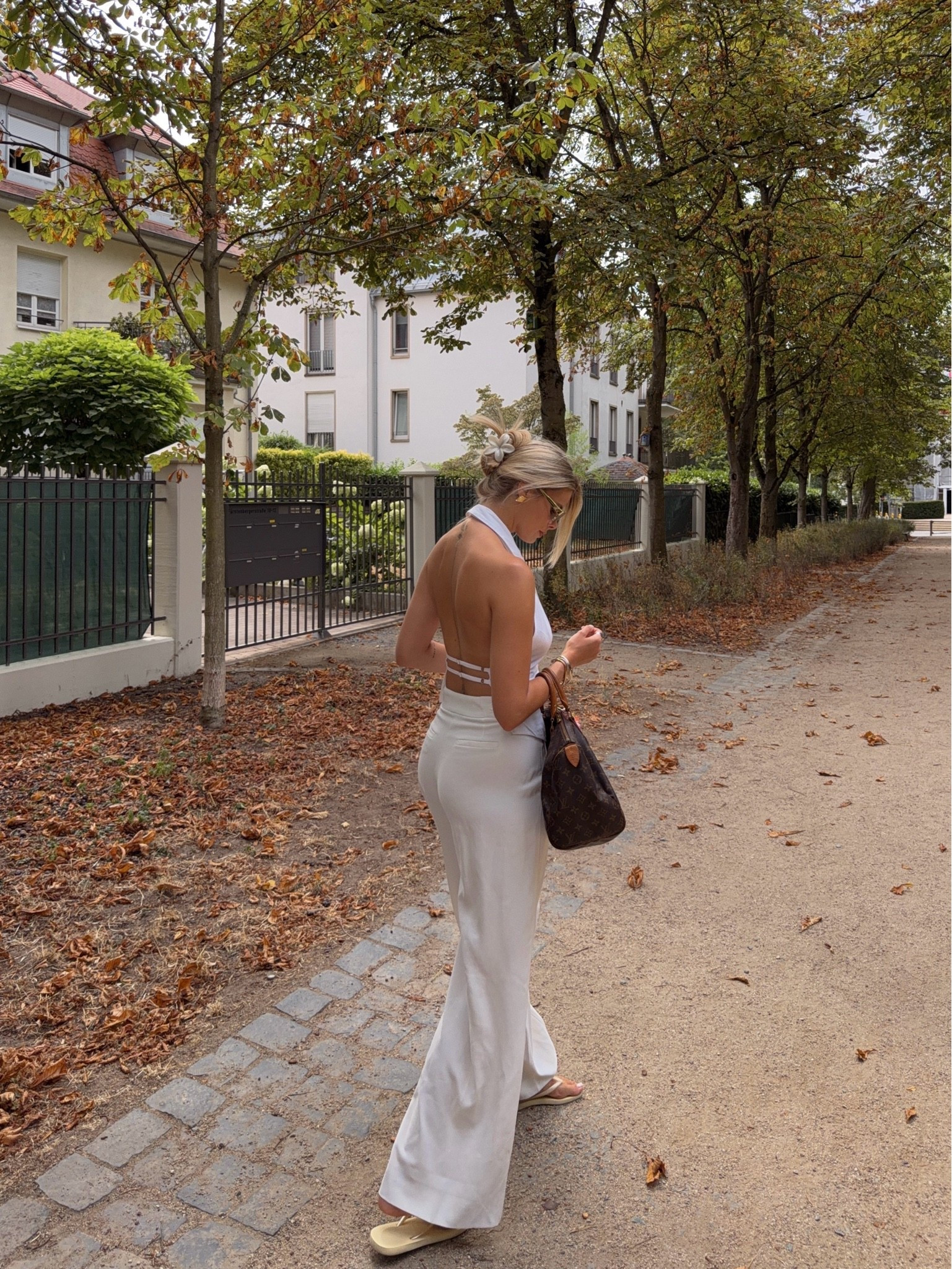 An effortless end-of-summer look with a clean, elevated feel. White wide-leg trousers paired with a backless halter top, neutral flip-flops and a classic brown bag create the perfect transitional outfit for warm late-summer days.

#LTKautumn #LTKsummer