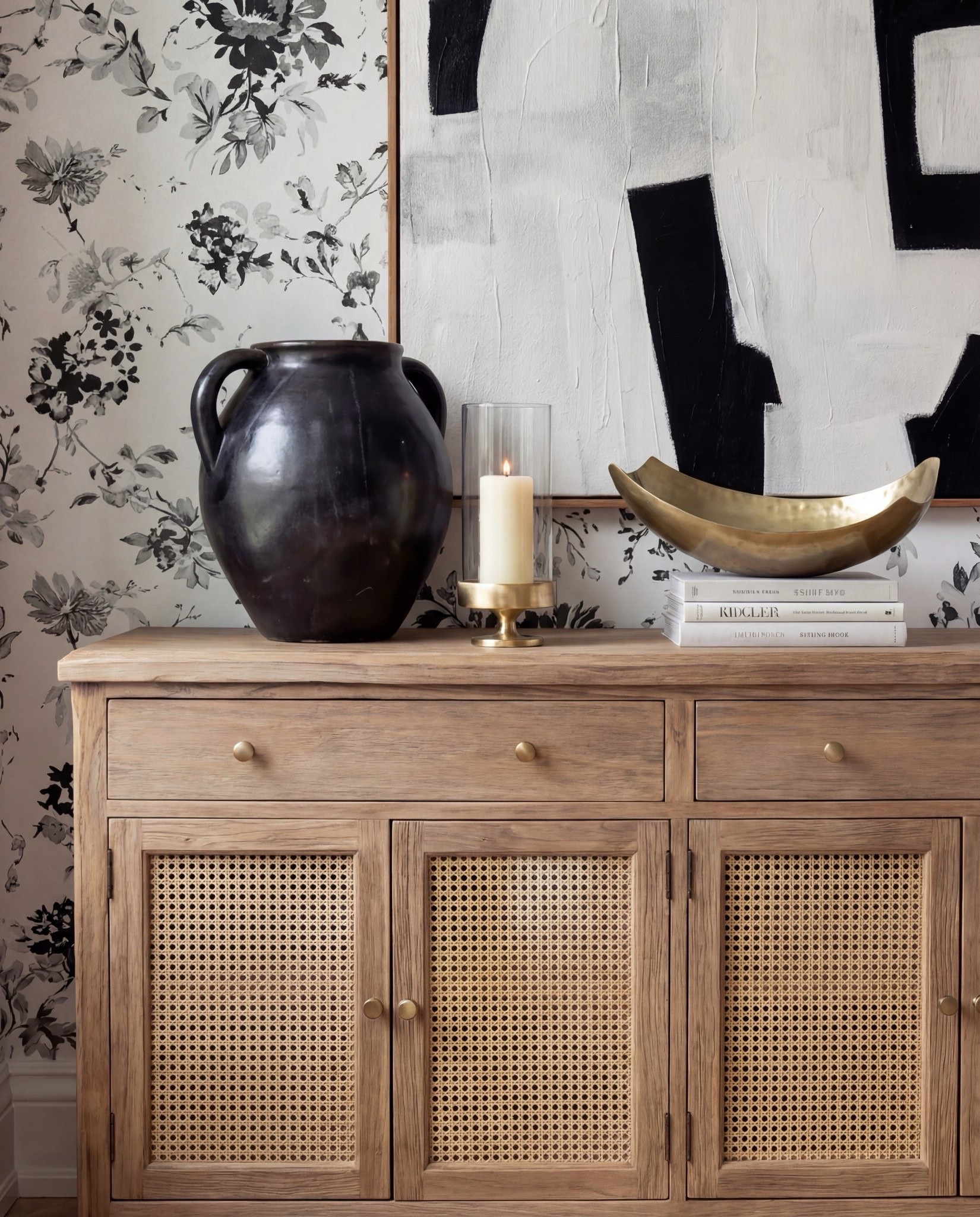 Shop the Look:
• Black fluted pedestal dining table with brass base
• Cream textured barrel dining chairs with brass foot detail
• Black & ivory floral wallpaper
• Soft geometric neutral area rug
• Light oak sideboard with rattan door insets
• Oversized abstract black-and-white wall art
• Terracotta ceramic vase with florals
• Black sculptural ceramic jar
• Brass decorative bowl
• Neutral hardcover styling books
• White glass globe pendant light


#LTKHome #LTKSaleAlert