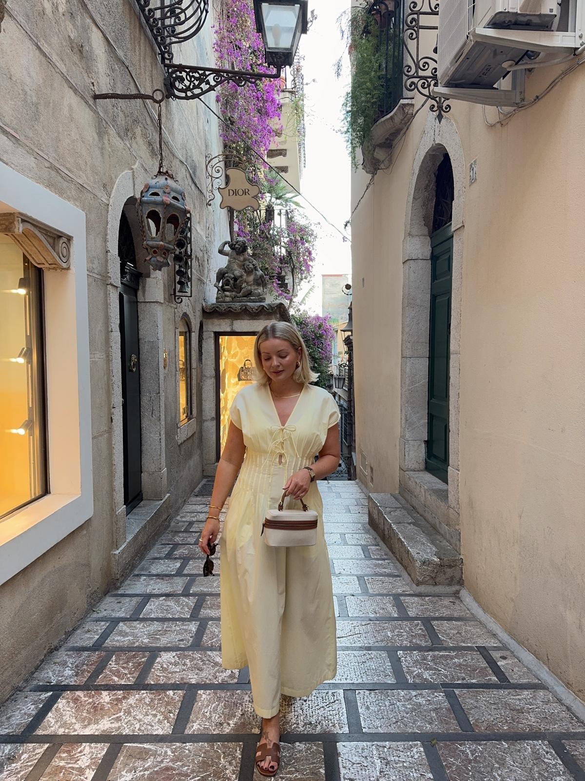 Summer holiday butter yellow dress outfit idea. Wat the brand butter yellow dress, Monica vinader gold snake chain necklace & Missoma gold chunky hoop earrings, canvas & tan small handbag, tan brown Hermes Oran sandals  

#LTKsummer #LTKuk #LTKstyletip