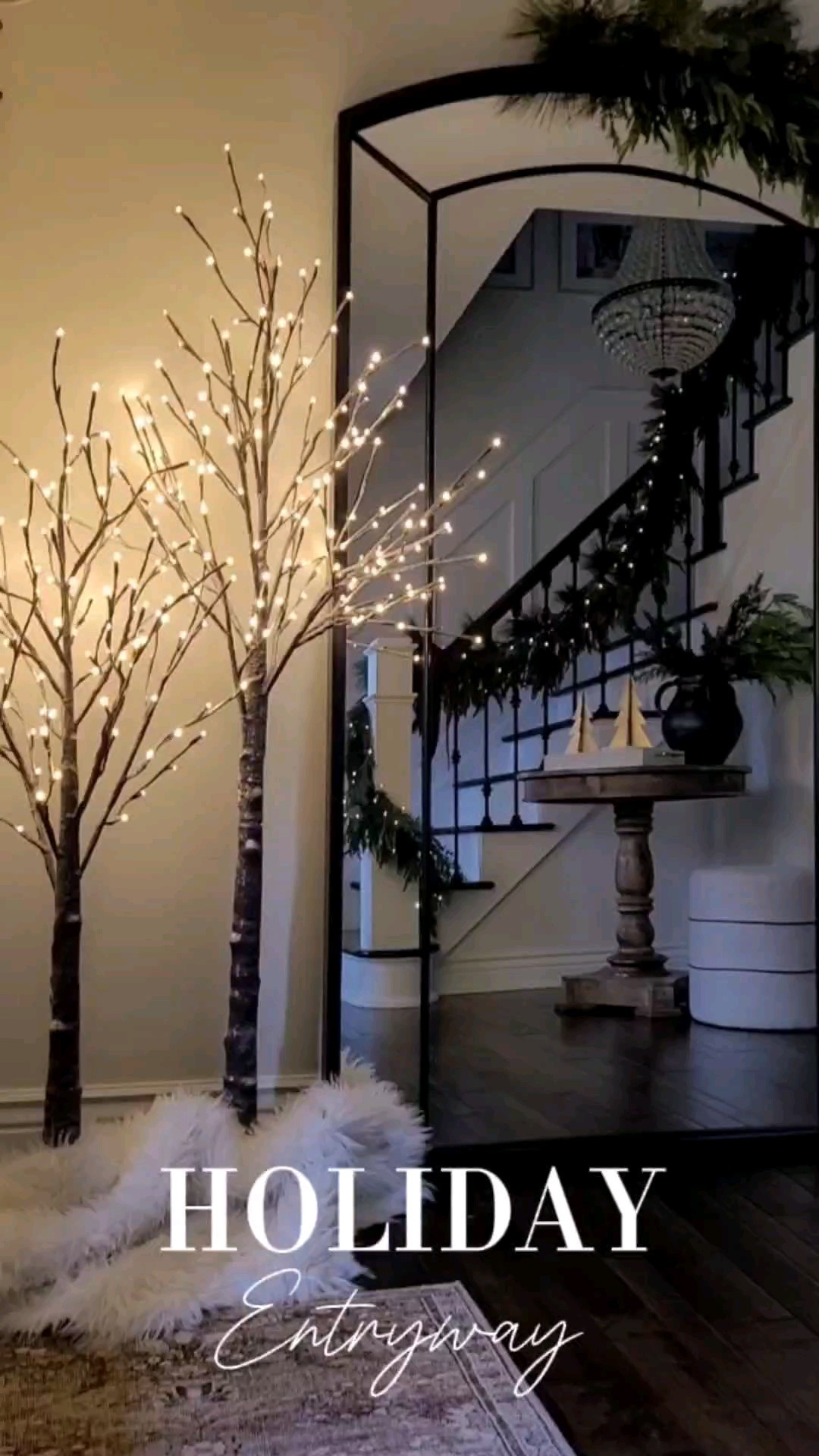 Holiday entryway inspo! I loved adding these twinkle trees to my foyer Christmas decor! This year I went with mixed garland,  velvet bow,  and bells on my staircase and floor mirror! 

#LTKWatchNow #LTKHoliday #LTKSaleAlert